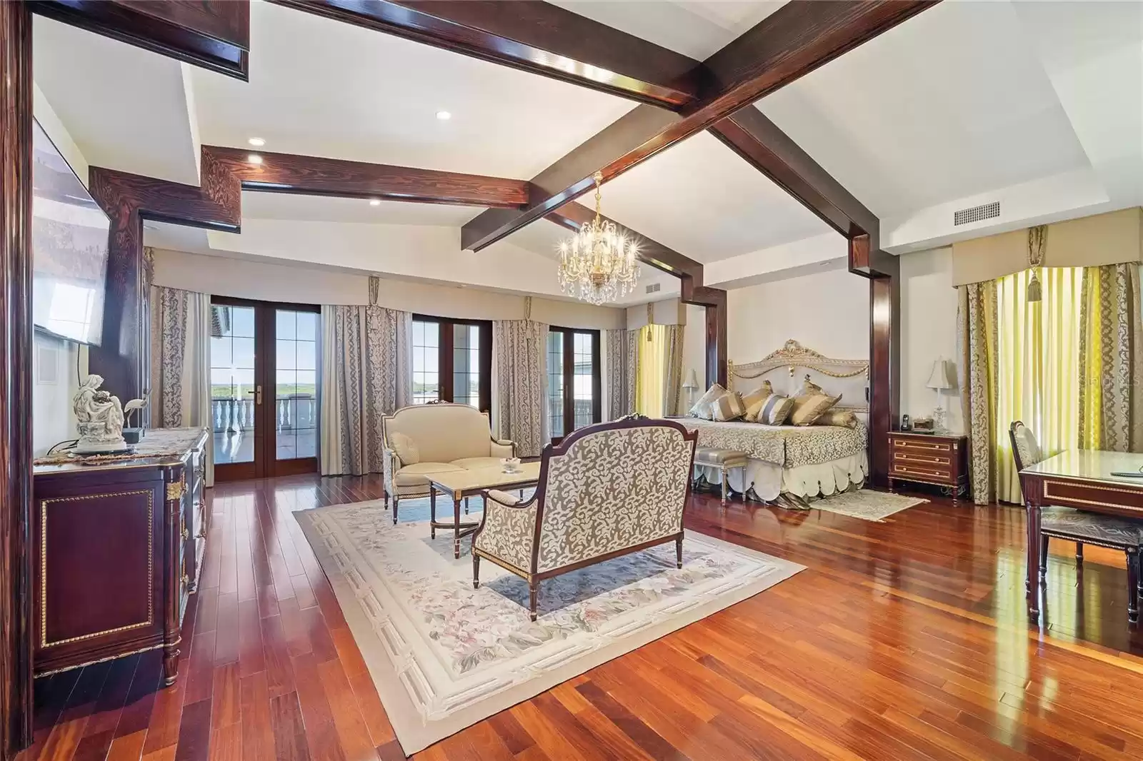 Royal Master Suite adorned with Rosewood flooring and ceiling beams