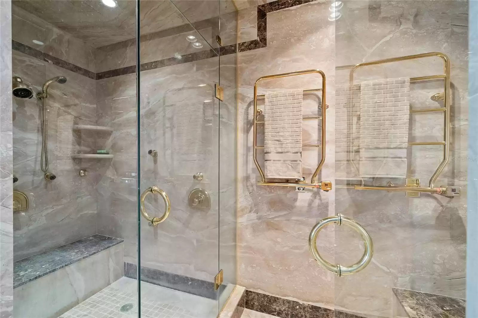 Steam shower in master bathroom with heated towel holders