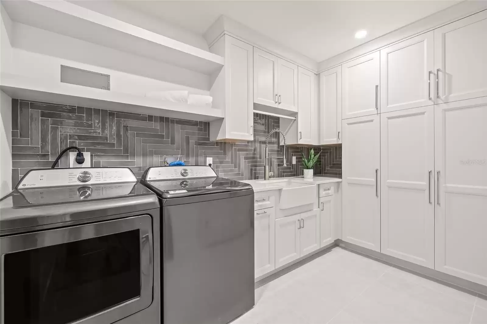 The Laundry room has plenty of storage options with a sink. The washer and dryer are included.