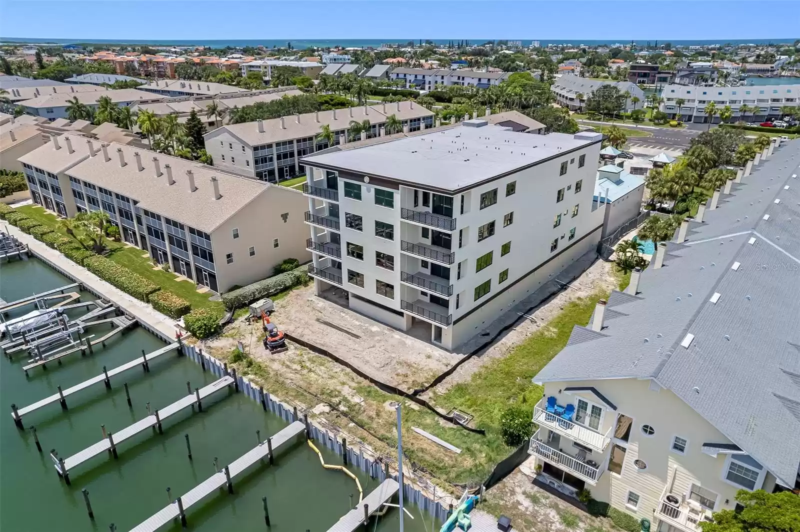 The land between the boat dock and the building will be a tropical pool and lanai oasis.