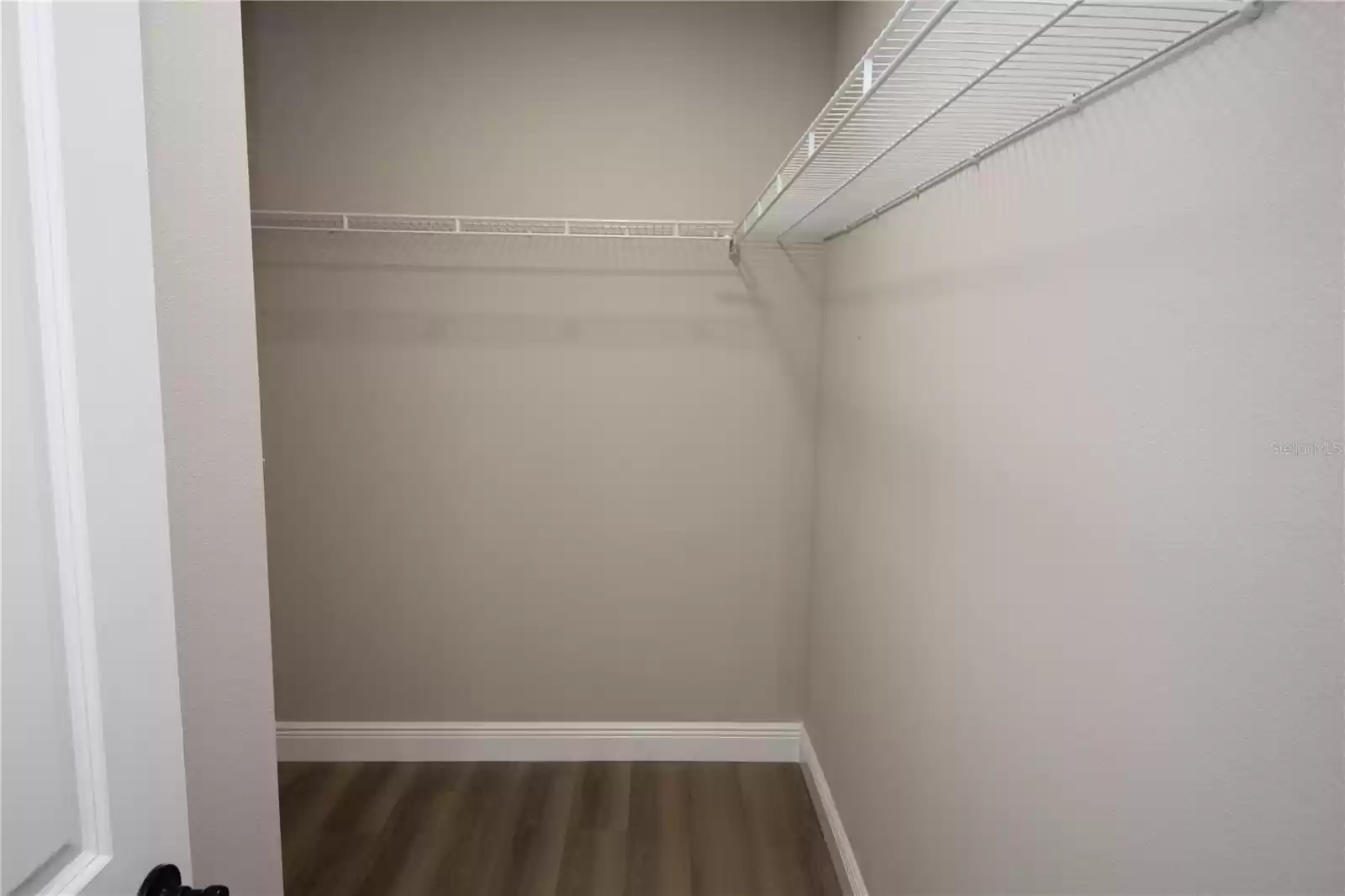 Large primary bedroom walk-in closet with new wire closet shelving