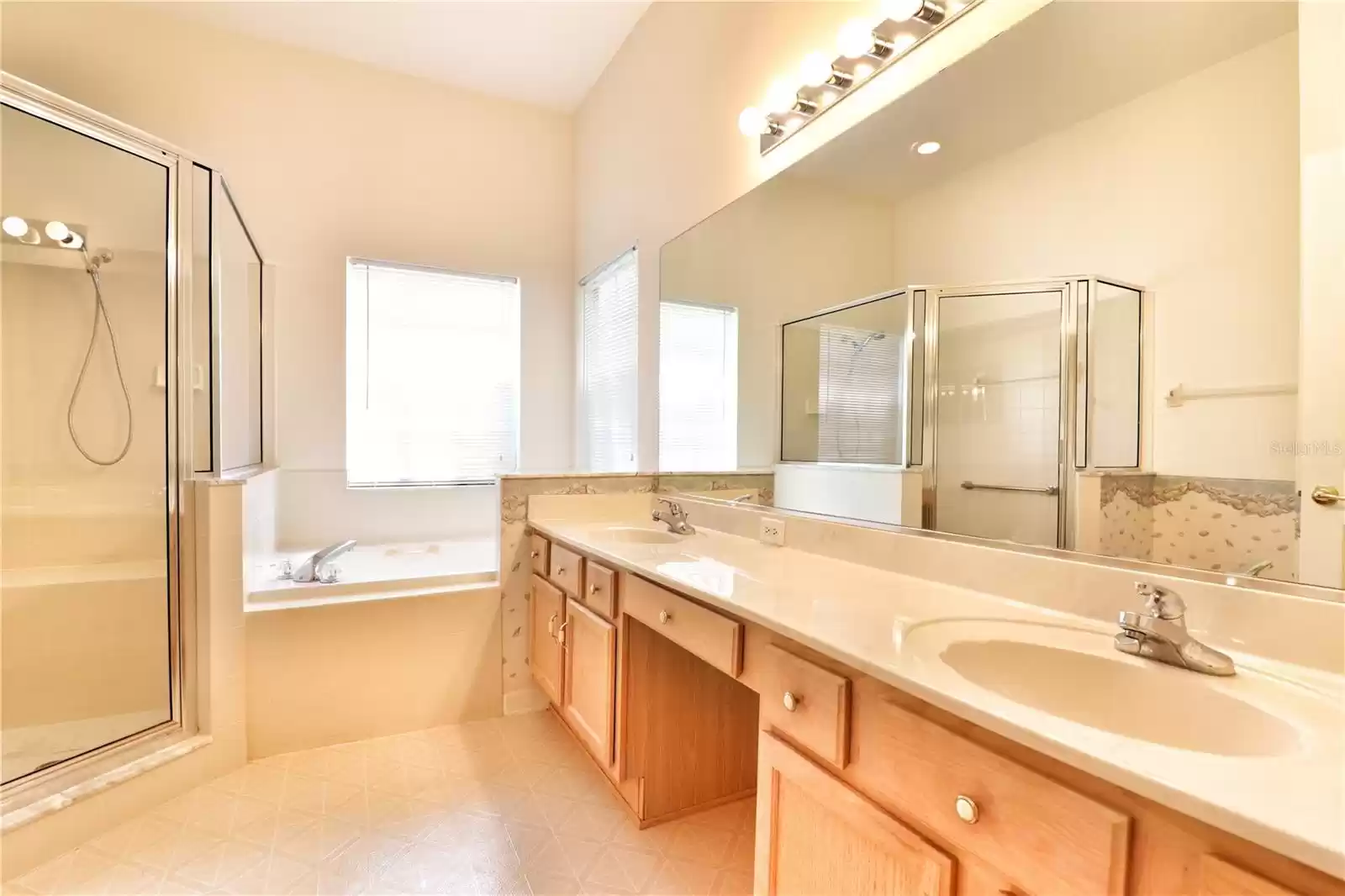 and bathroom with shower enclosure, garden tub and dual sink vanity