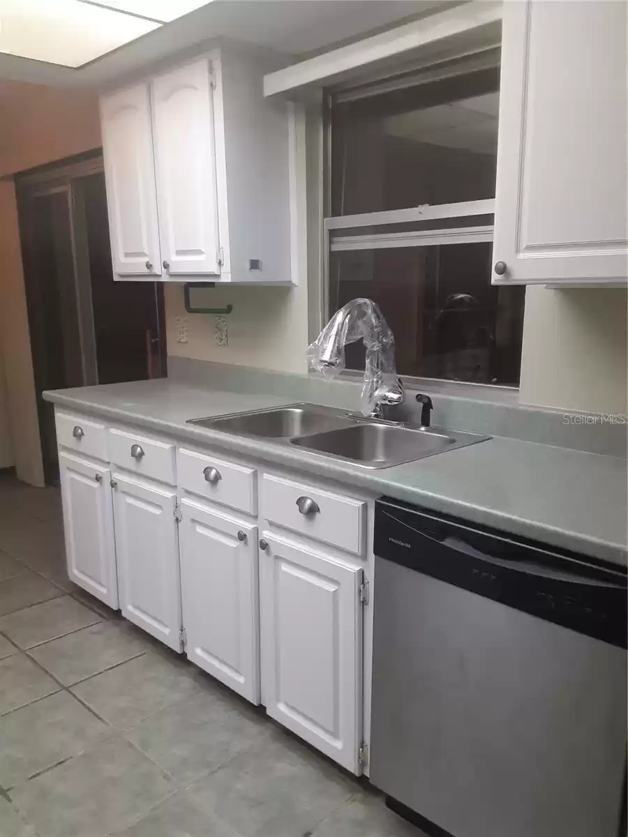 tiled kitchen with new pull-down kitchen faucet and new dishwasher