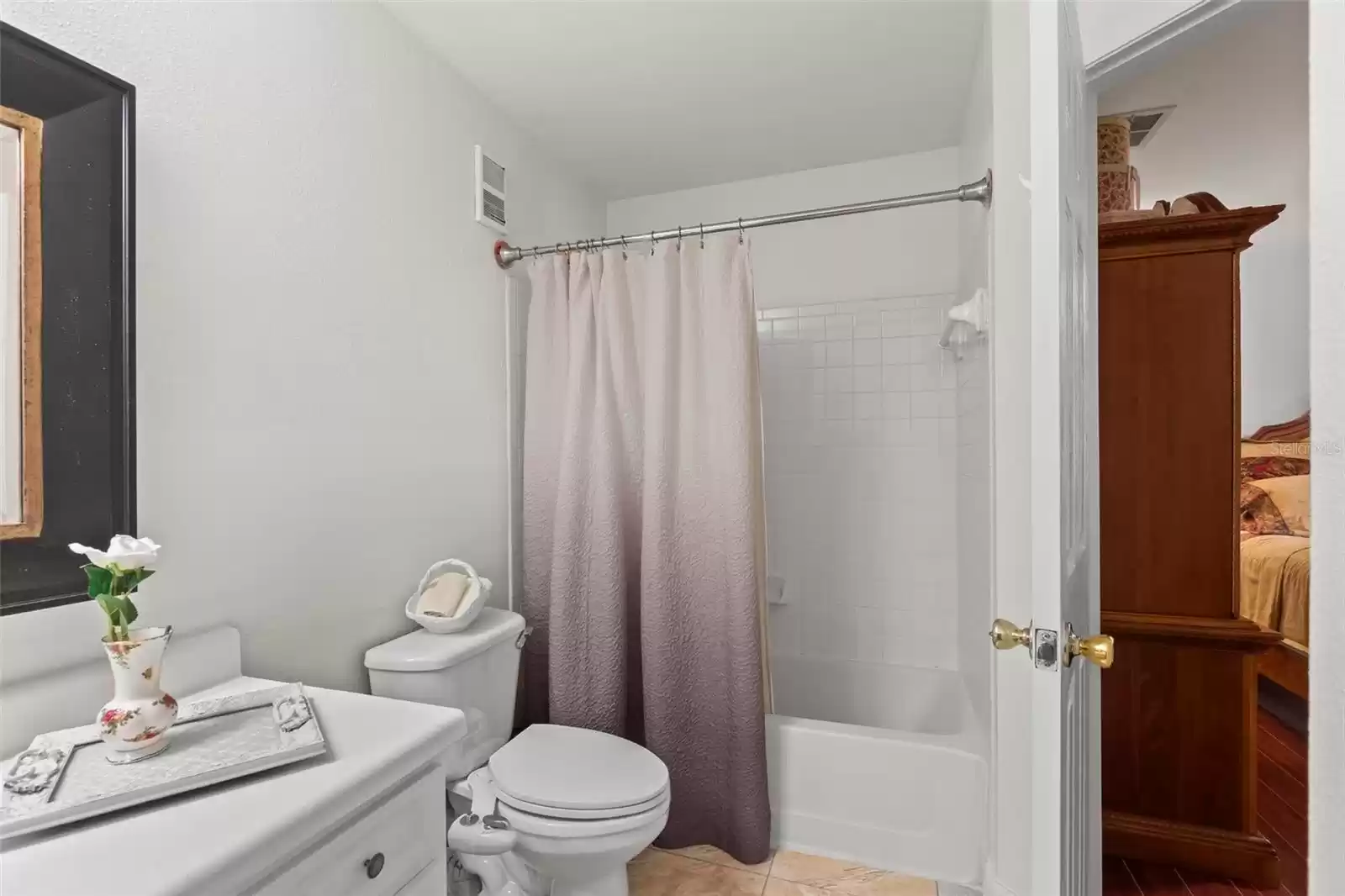 En-Suite Master Bath with Shower/Tub Combination and Neutral Tile