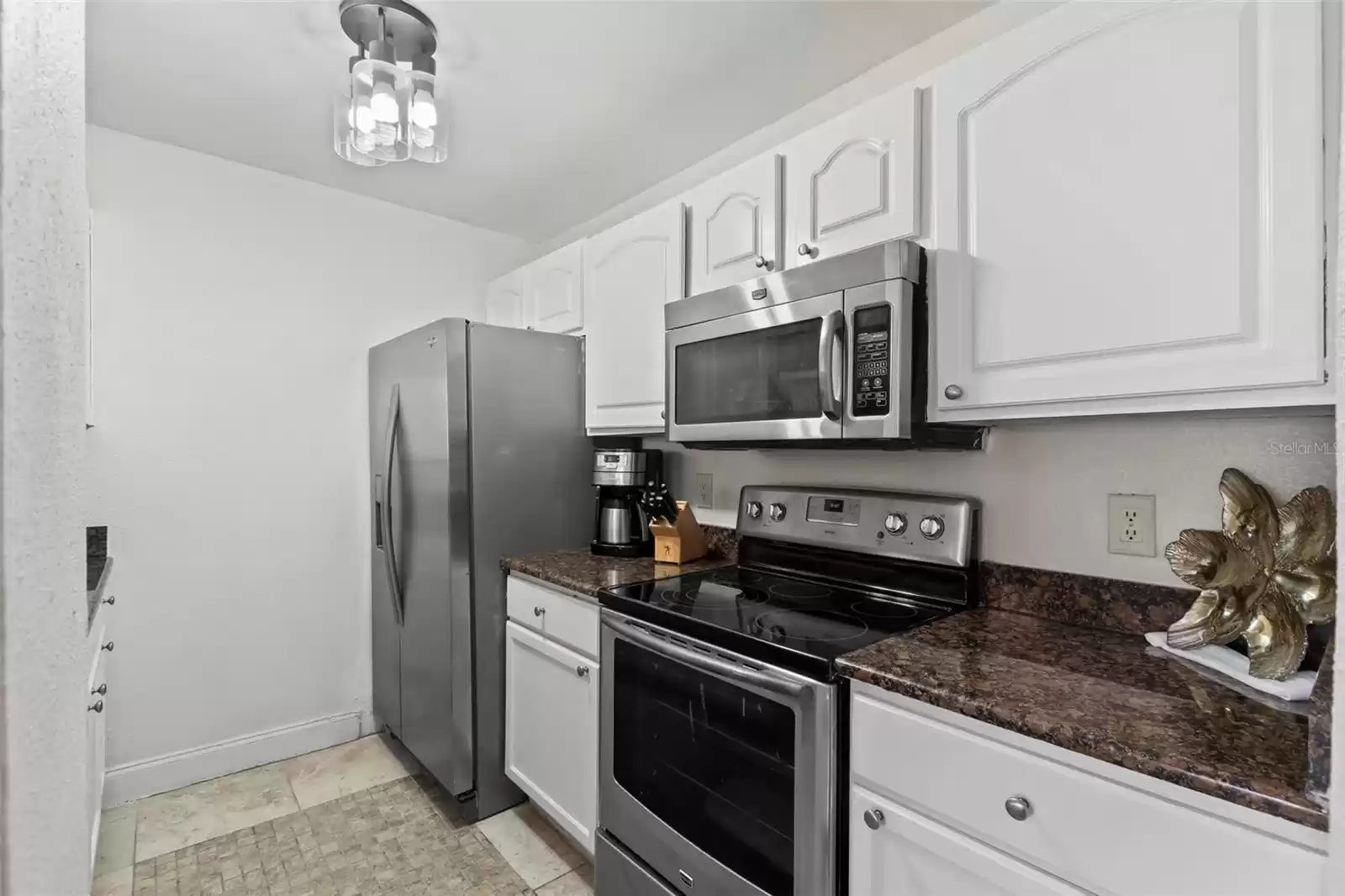 Kitchen with In-Laid Tile Flooring Includes All Stainless Appliances, Recently Refaced Wood Cabinets, Granite Counters, New Modern Flush Mount Hampton Bay 3 LED Light Fixture, New Sleek Industrial Grade Pull-down Faucet and Breakfast Bar that Opens to the Living Area