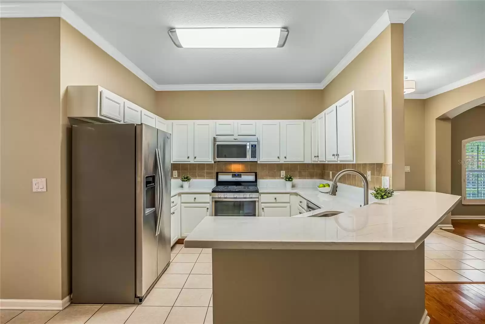 Kitchen w/ natural gas convection range, tile backsplash underneath cabinets