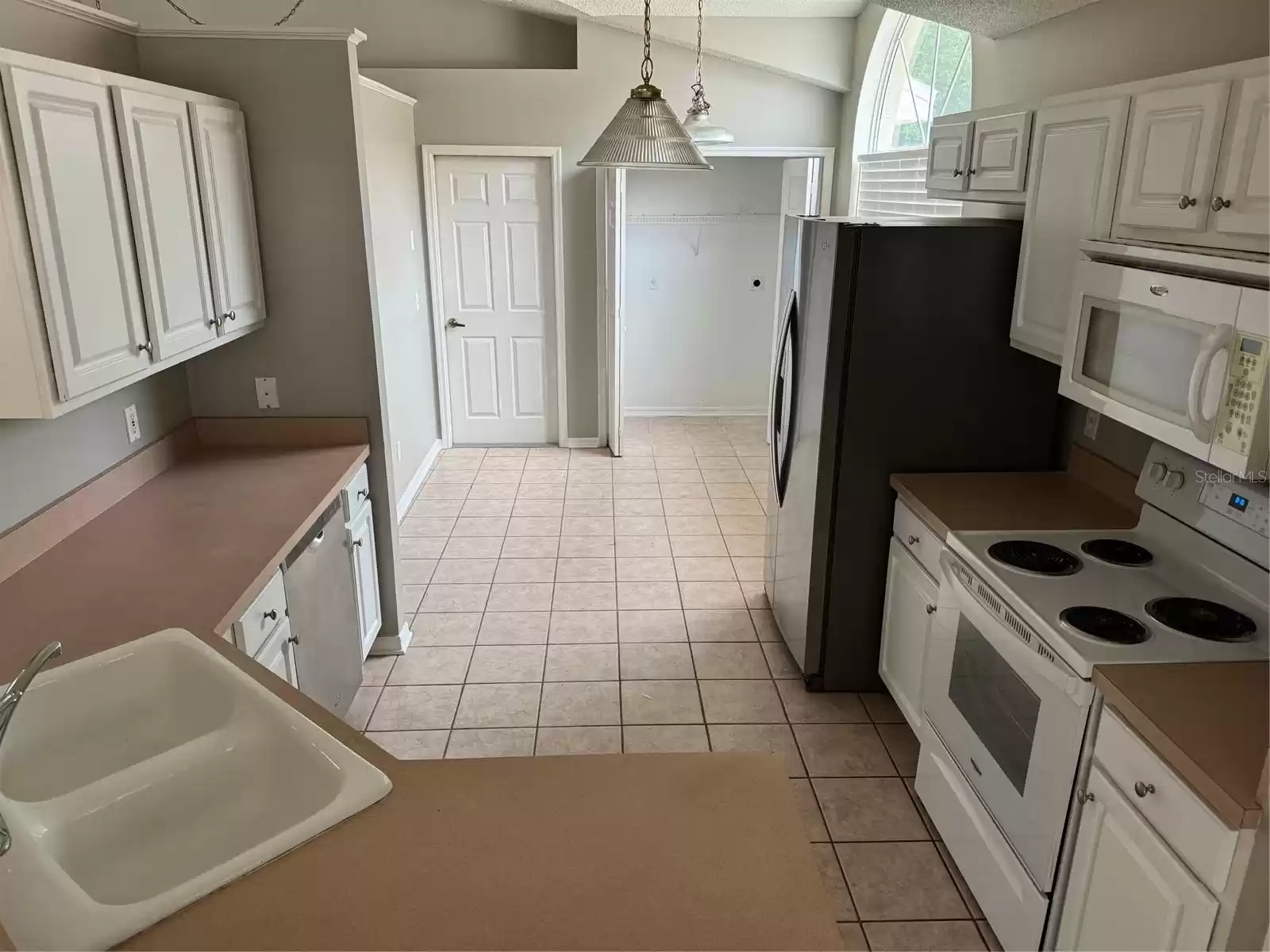 Kitchen view toward garage entry and utility closet.