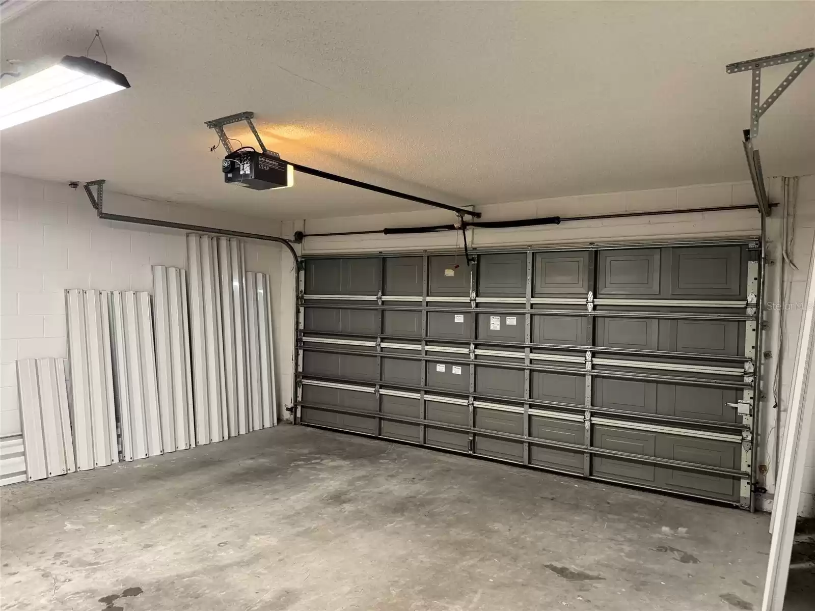 Garage View to Opener, Door and Hurricane Shutters.