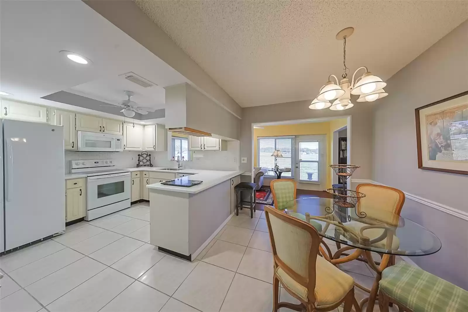 Kitchen is bright, open and spacious, with a tray ceiling, recessed lighting and a ceiling fan for comfort while cooking.  The eat-in area is convenient and even has a view of the golf course.