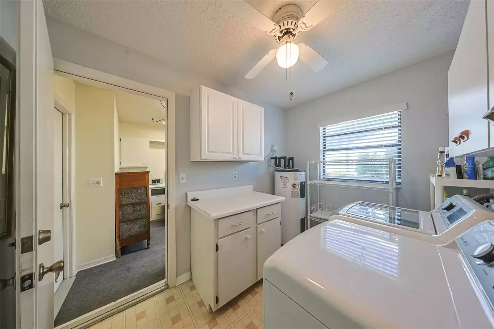 Laundry Room just off of the Kitchen with ceiling fan and plenty of storage available. Washer and dryer are 2022.