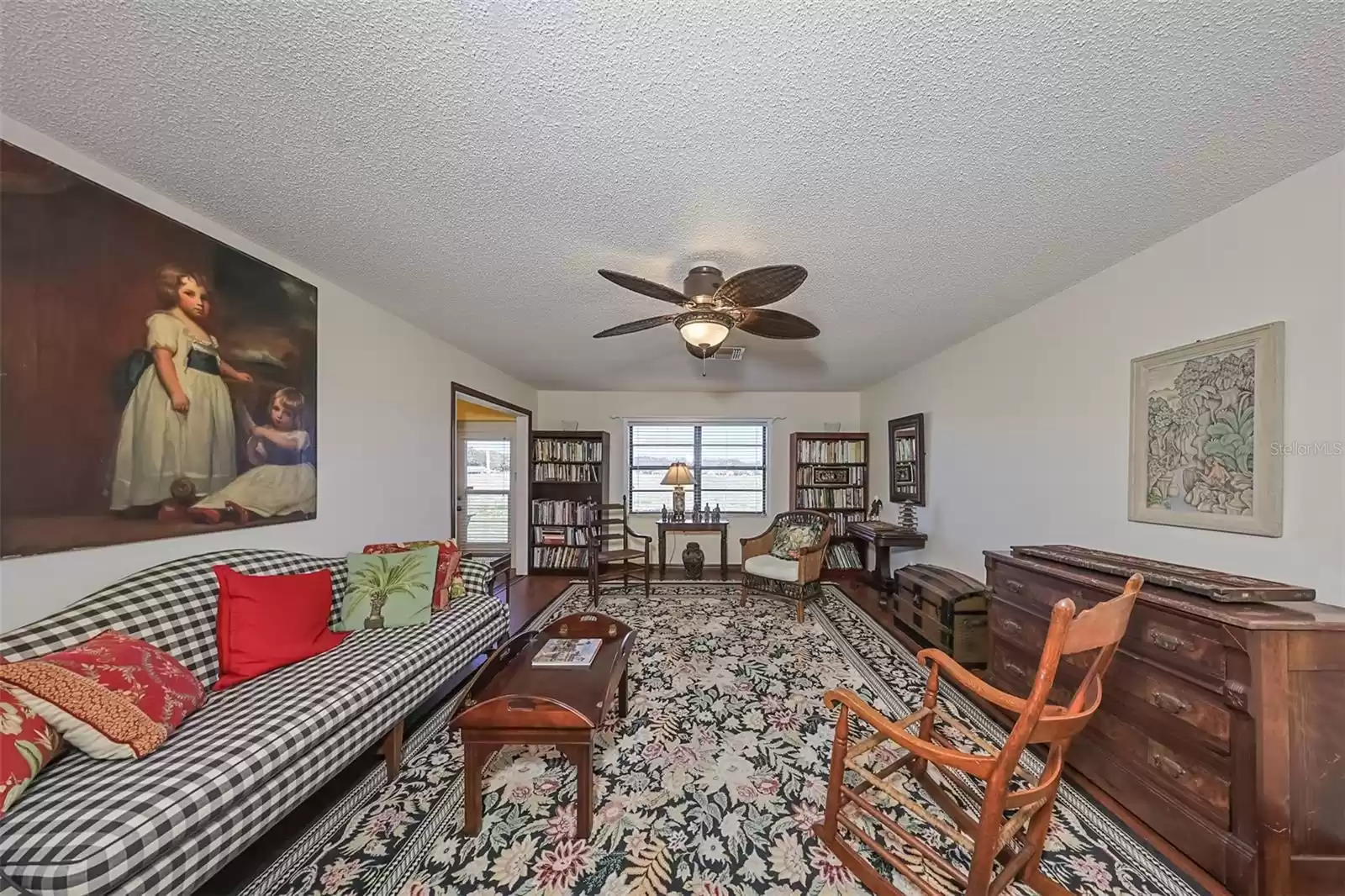 Living Room has neutral colors with a custom ceiling fan including lights.  All furniture and furnishings are remaining with the home, but the seller will remove upon request of the buyer.