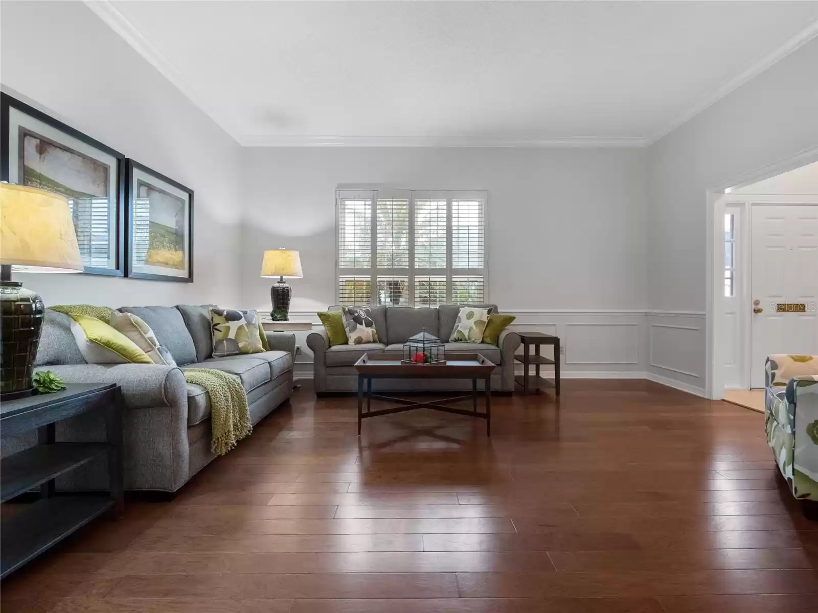 Living room with wainscoting, crown molding, shutters