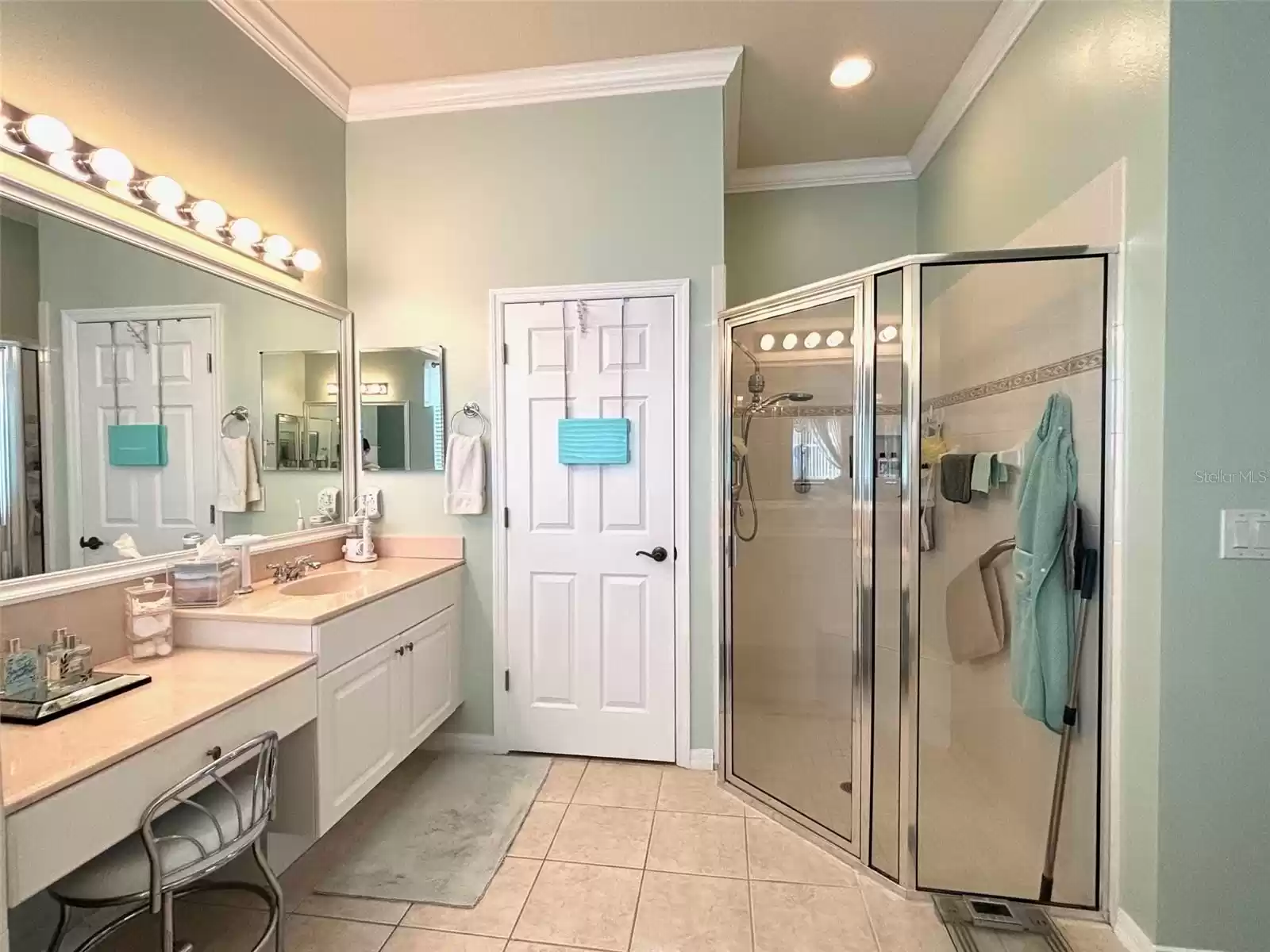 Primary bathroom - split vanities with built in dressing table. Spacious tile shower with seat.