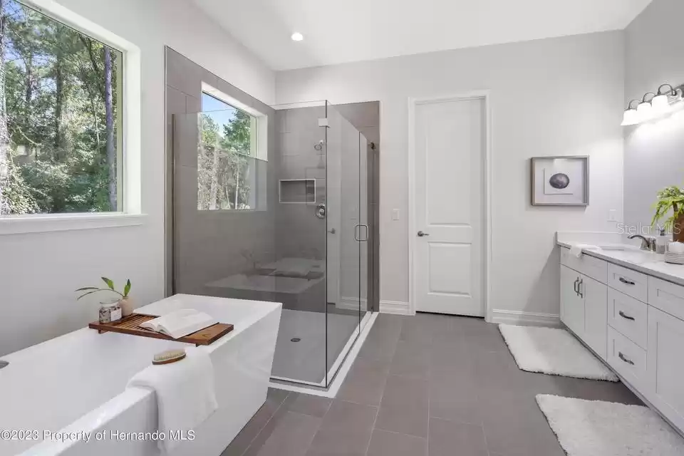 Primary bath frameless shower with stand alone soaking tub