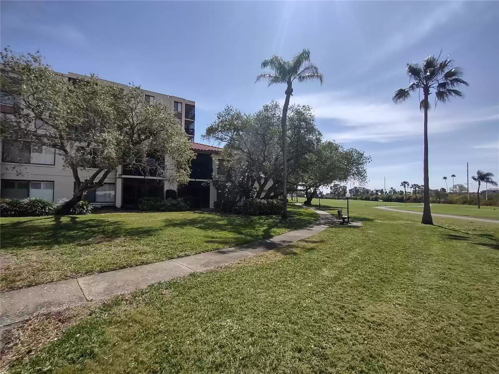 Unit #110 is the second screened patio in from the end. Strolling walkway & bench overlook the 5th fairway.