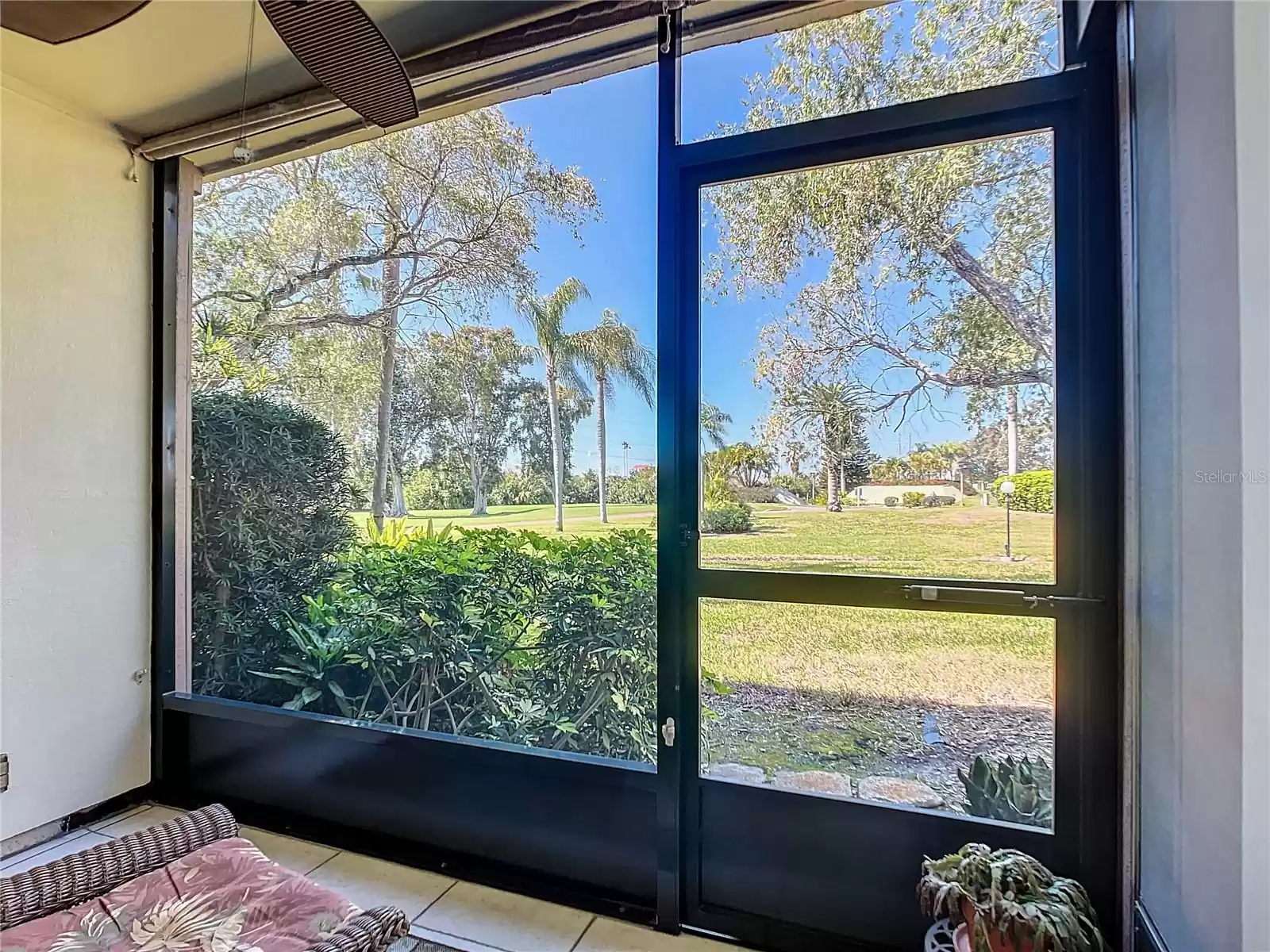 Tranquil and tropical views of the 5th fairway from the enclosed patio. New screen enclosure, tile floors, and easy to stroll the grounds.