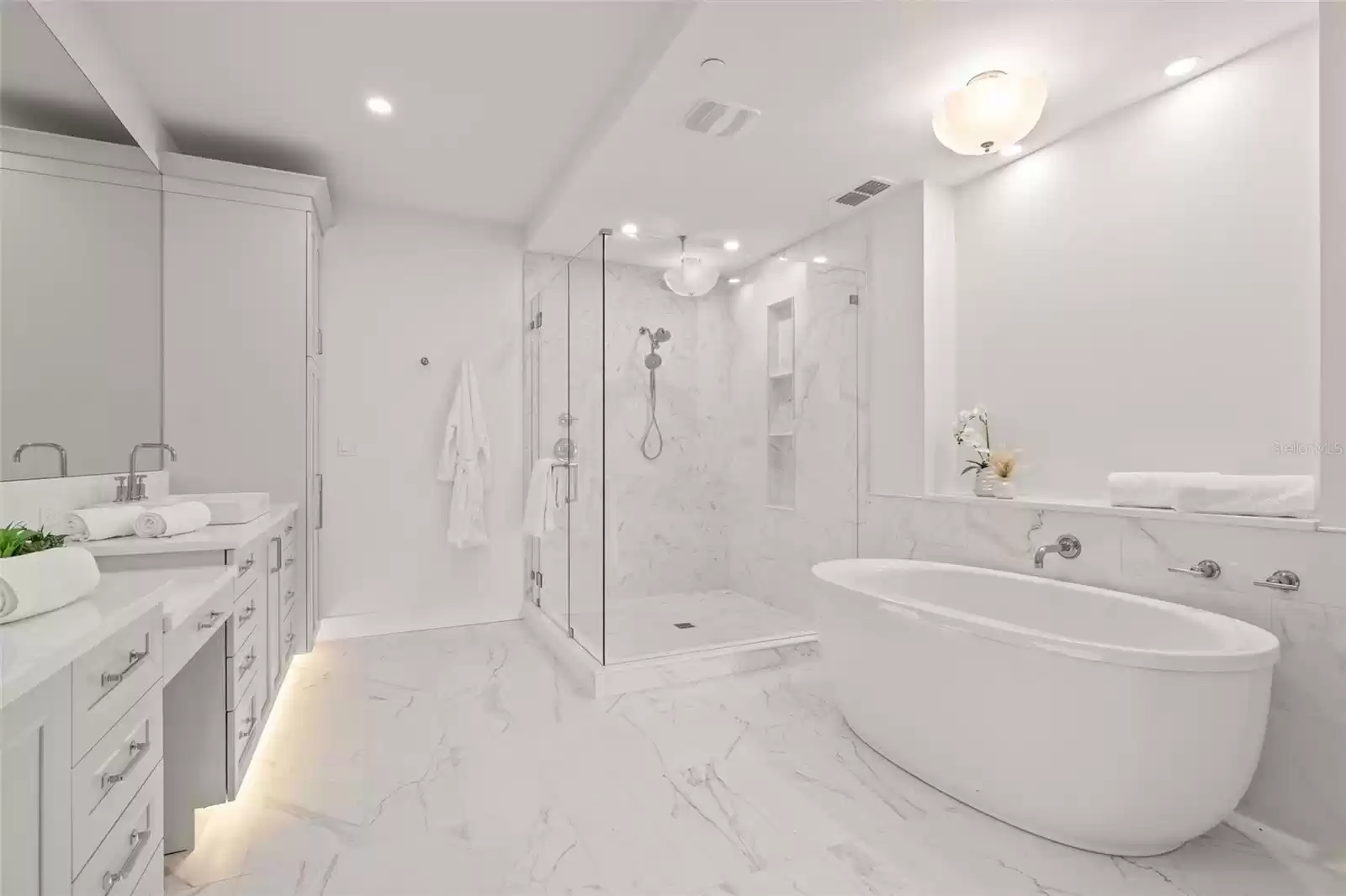 The owner's bathroom is luxurious, with two sinks, a vanity, a large walk-in shower, and a soaking tub.