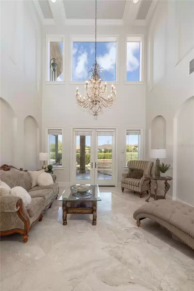 Formal living room with doors that open to the pool