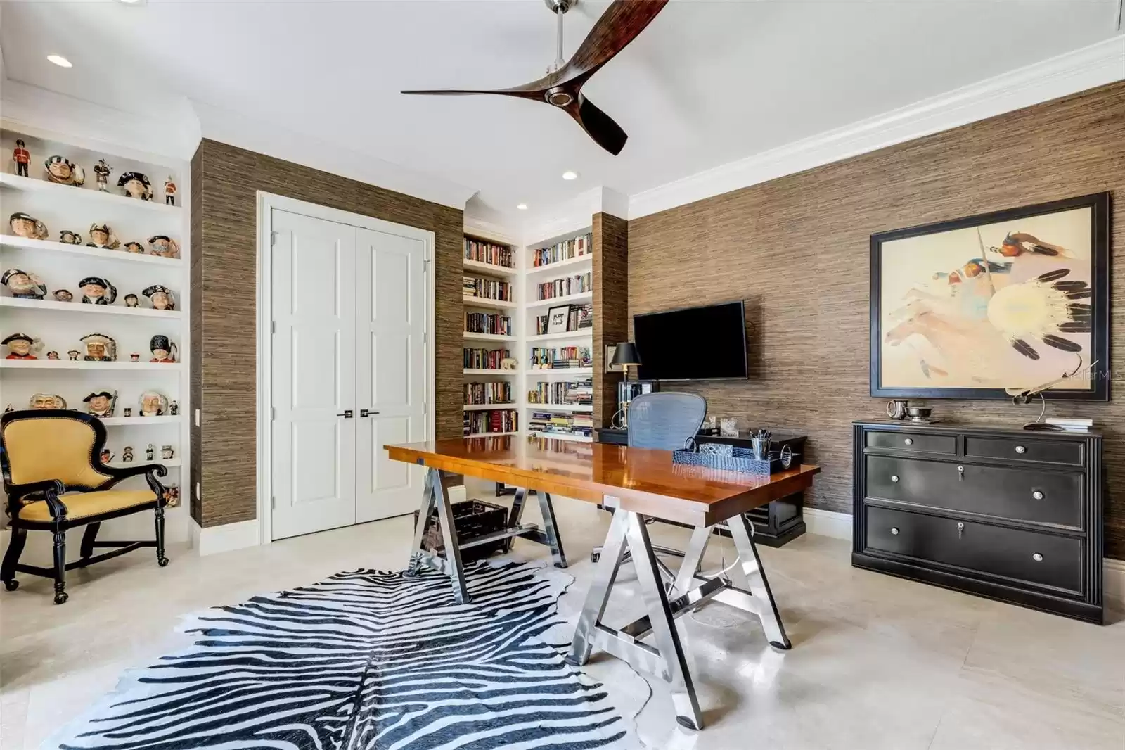 The oversized office affords unobtrusive bookcase and display space