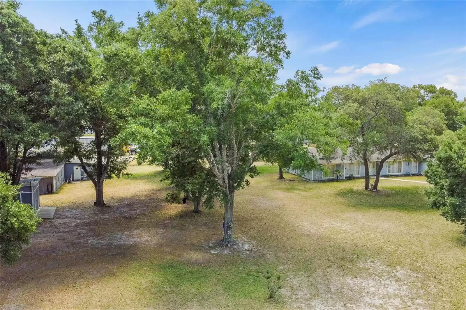 View of property with garage & shop bldgs on left