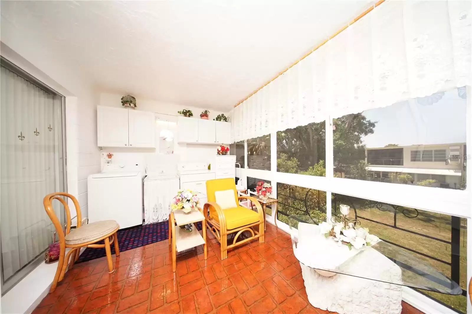 Florida room with washer and dryer and built in cabinets on the south wall of Fl room.