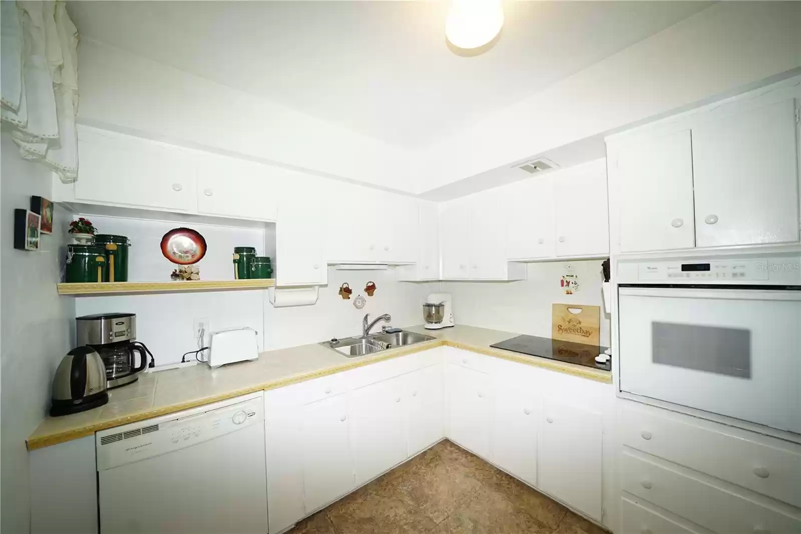 Kitchen with smooth cook-top, newer built in oven, and dishwasher.