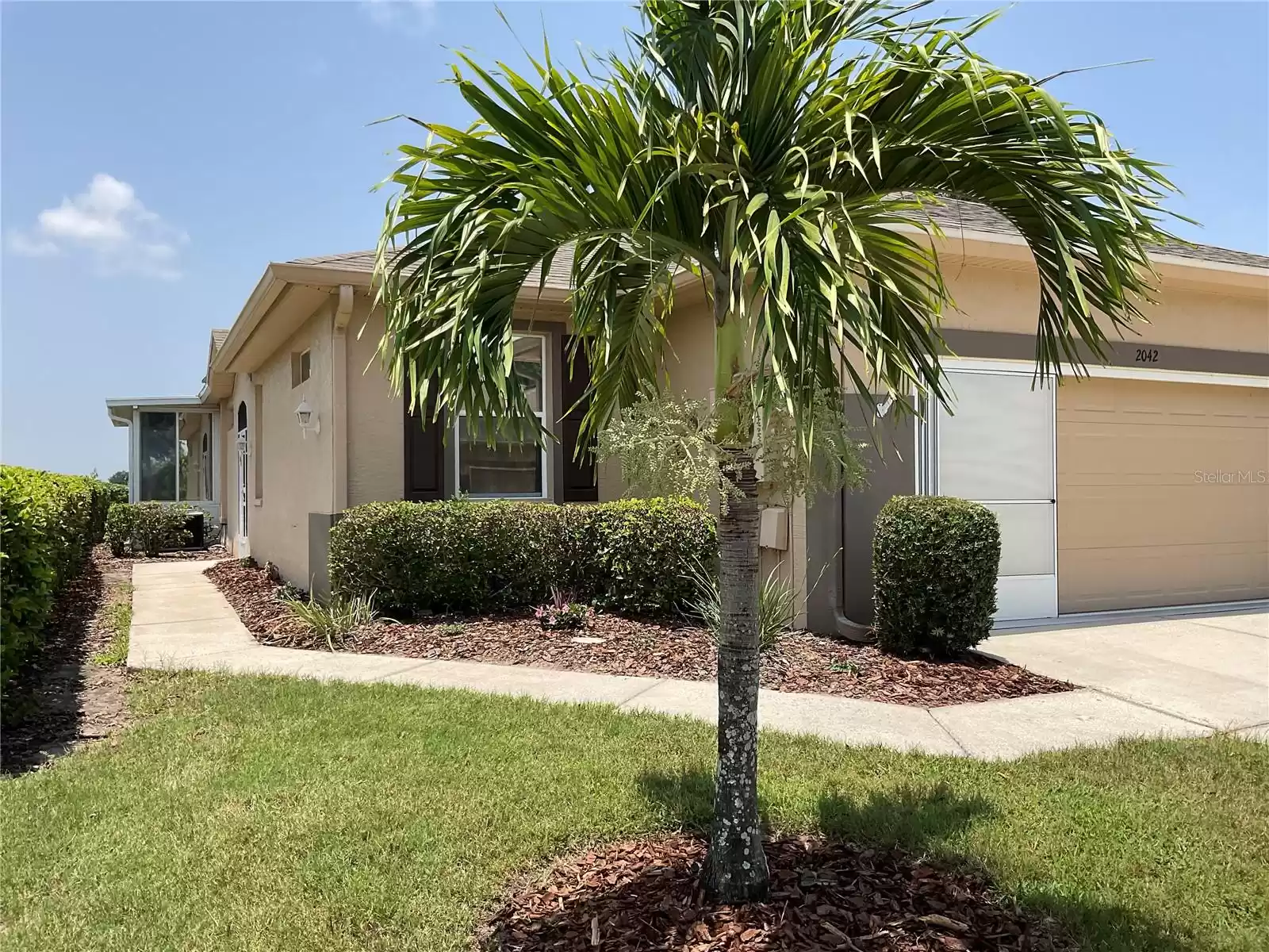 Private entrance on left side of driveway with privacy hedges