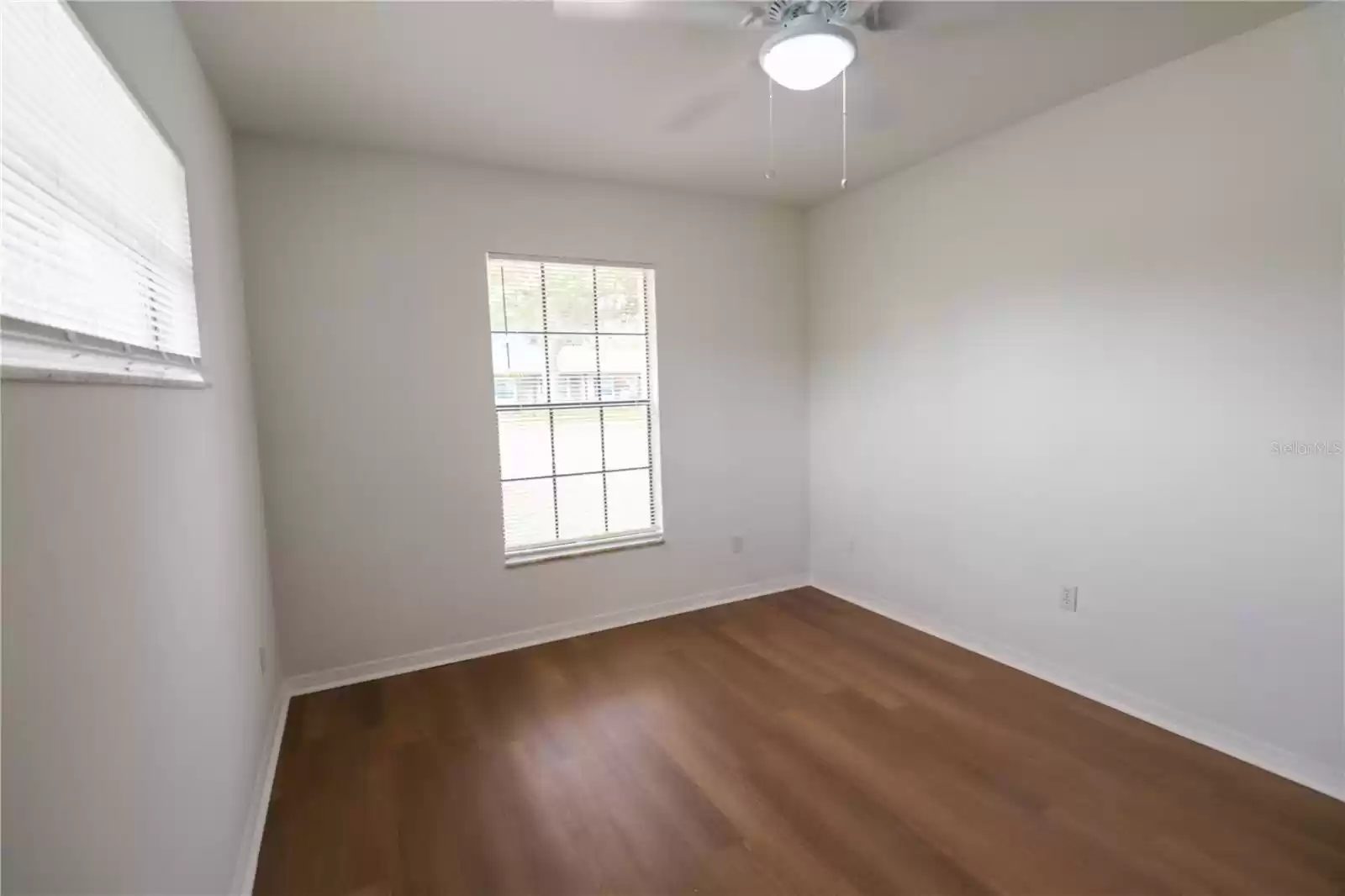 The second bedroom, two windows and with a ceiling fan.