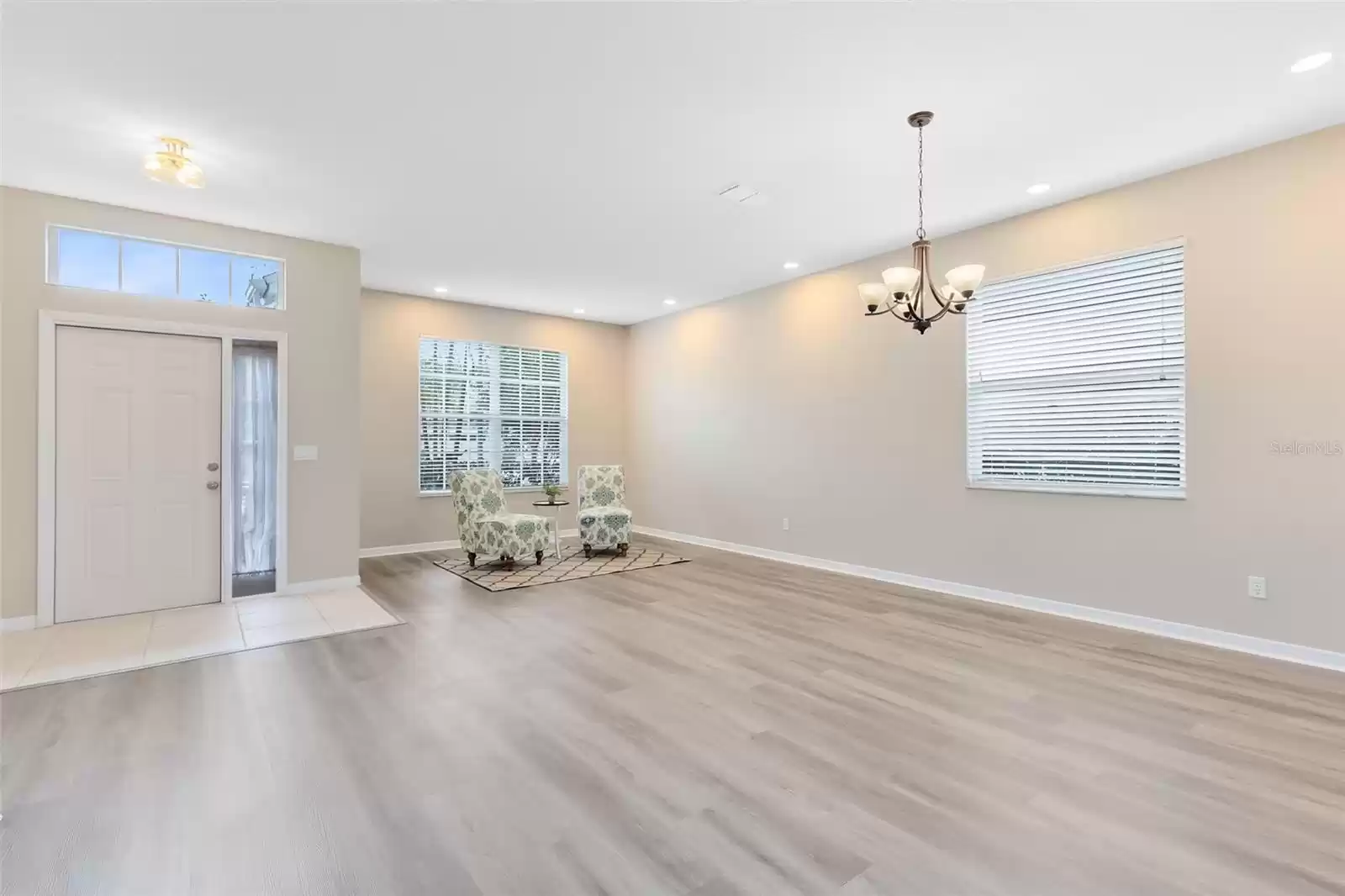 BRIGHT AND BEAUTIFUL LIVING AND DINING ROOM WITH NEW PAINT AND NEW LUXURY VINYL PLANK FLOORING THROUGHOUT THE DOWNSTAIRS