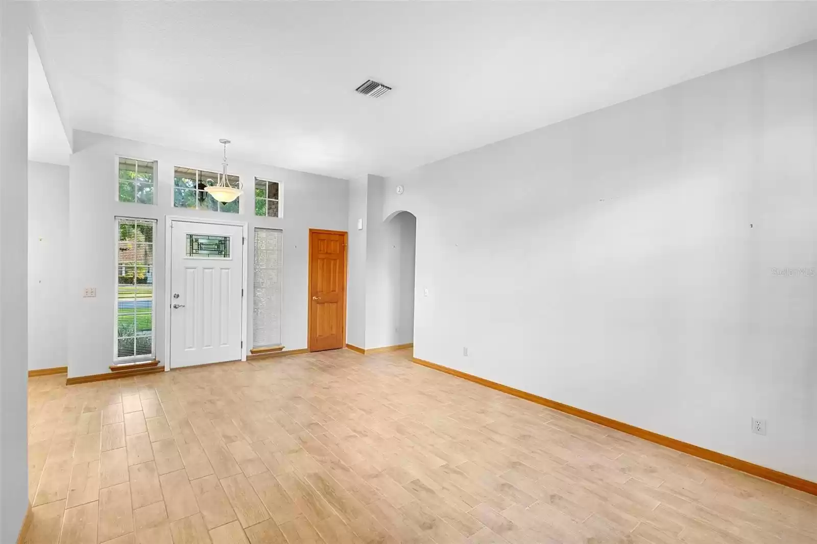 Front living room towards front door. The tall ceilings and natural light create a spacious feel.