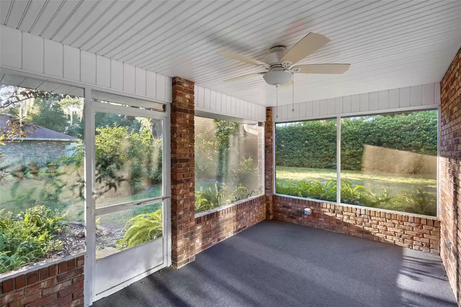 Brick screen room includes a fan and light.