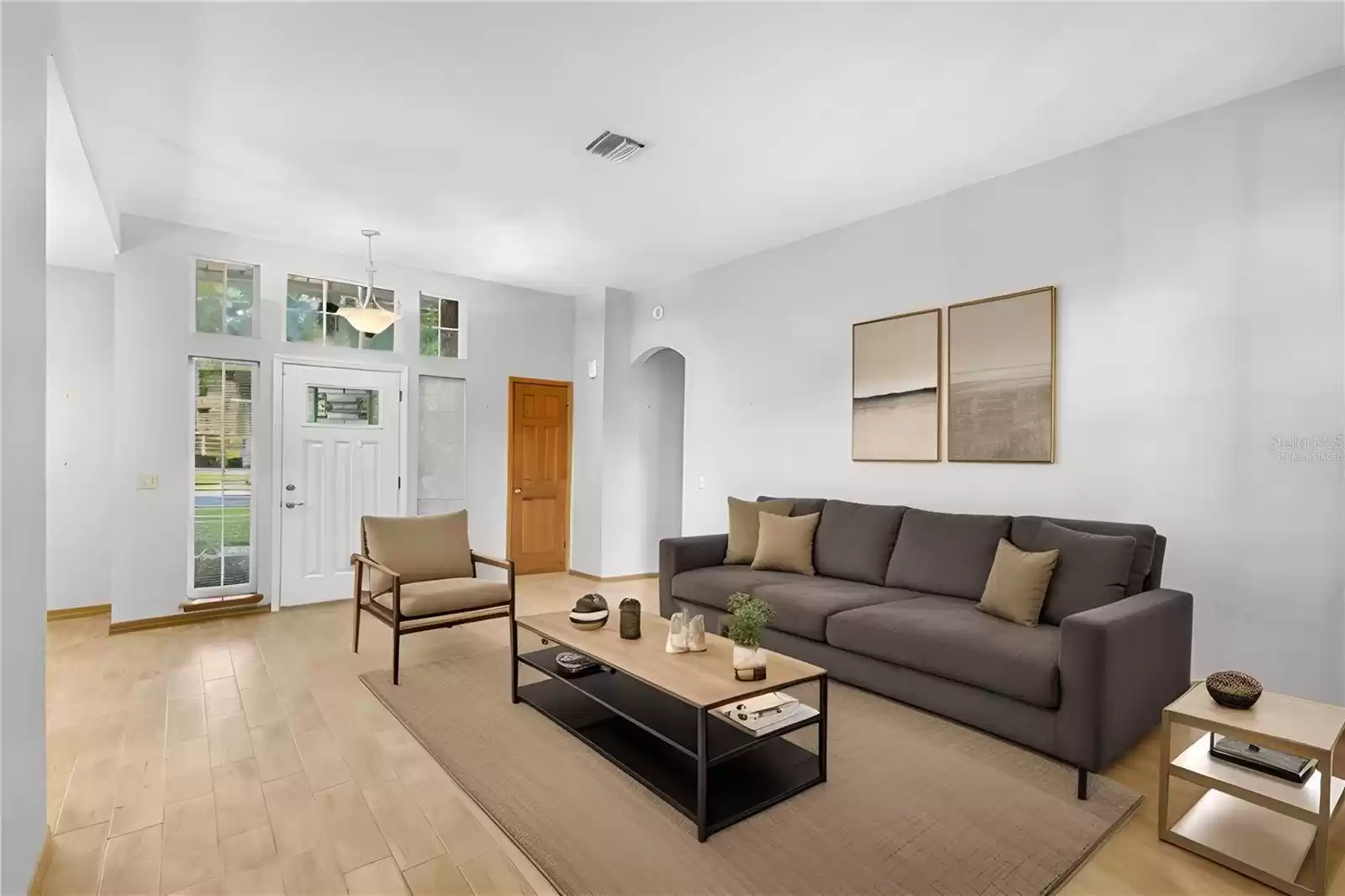 *Virtually staged* Front living room towards front door. The tall ceilings and natural light create a spacious feel.