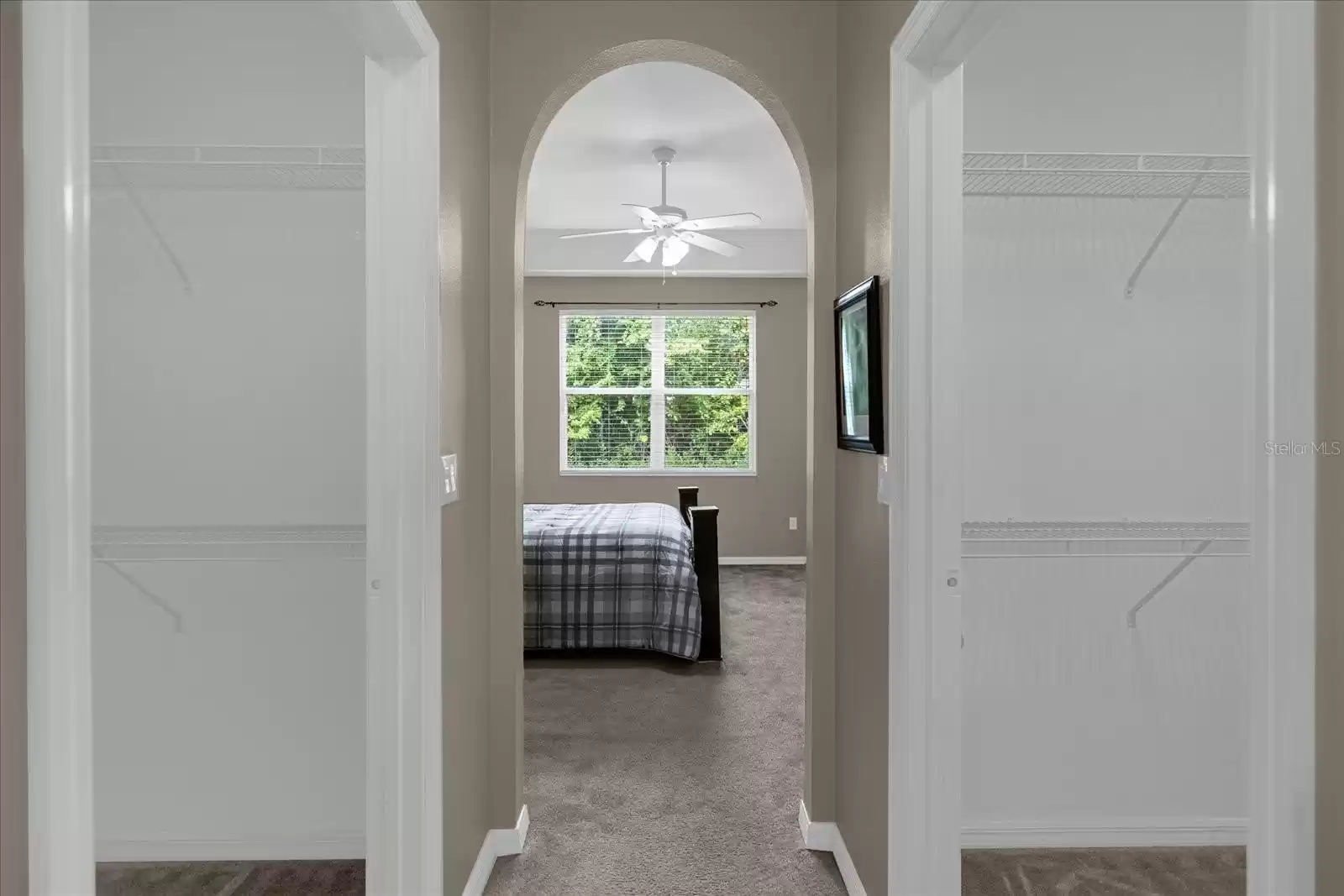 Hallway with his and her closet entering to master bathroom.