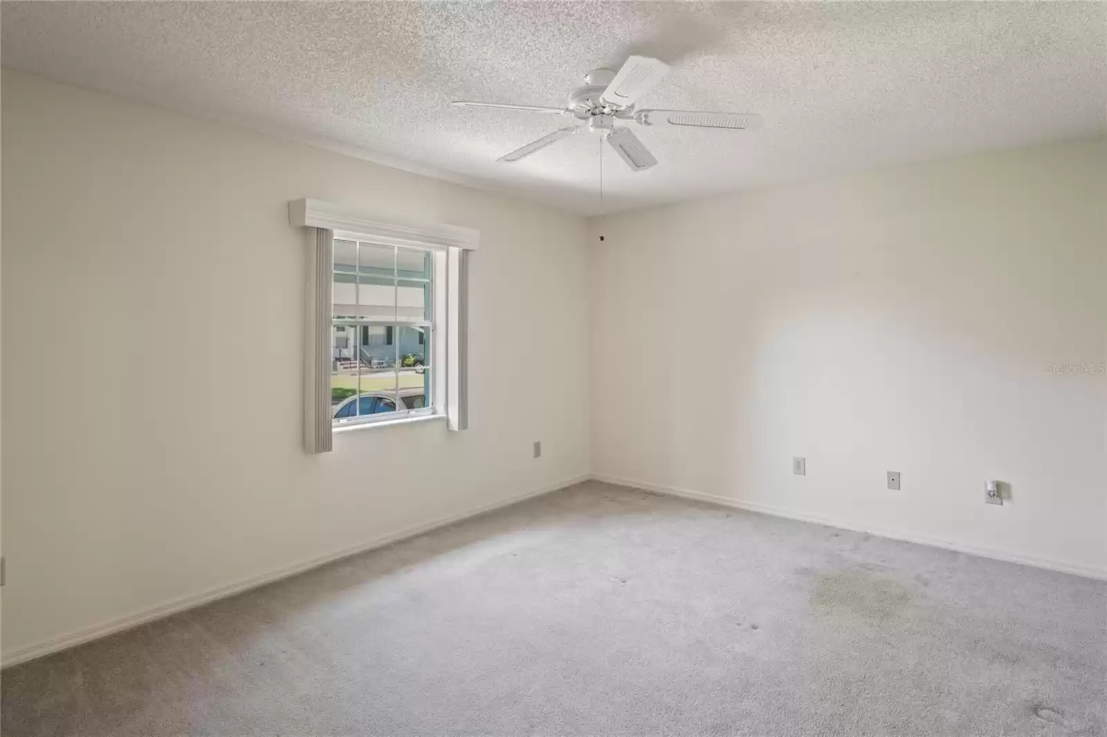 Primary bedroom has a ceiling fan, and a walk in closet