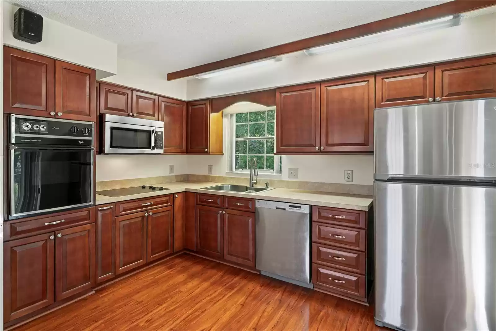 Kitchen has dishwasher, wall oven, stove top, dishwasher and refrigerator. garbage disposal and the slider leading onto the back yard.