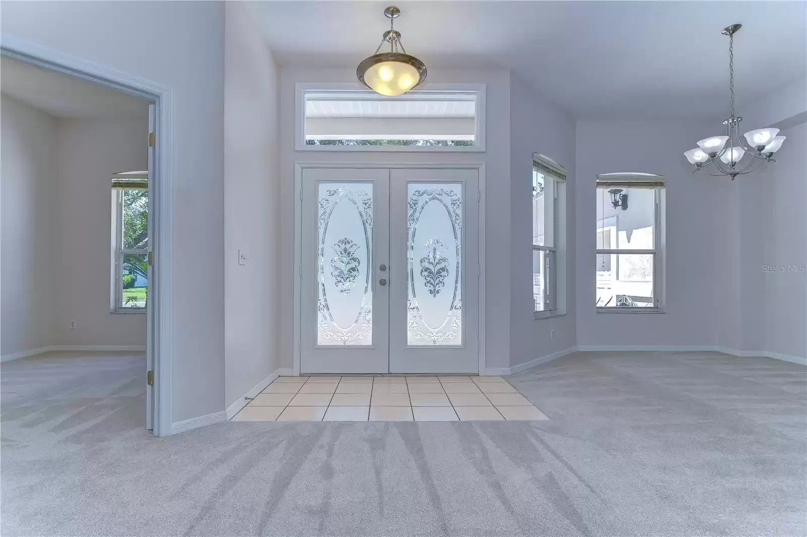 Bright foyer with double decorative glass front doors and a transom window!