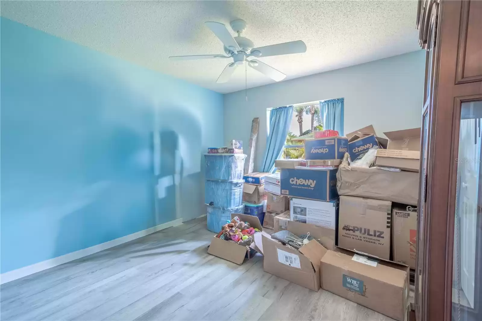 3rd bedroom features luxury vinyl flooring, a built in closet and a ceiling fan.