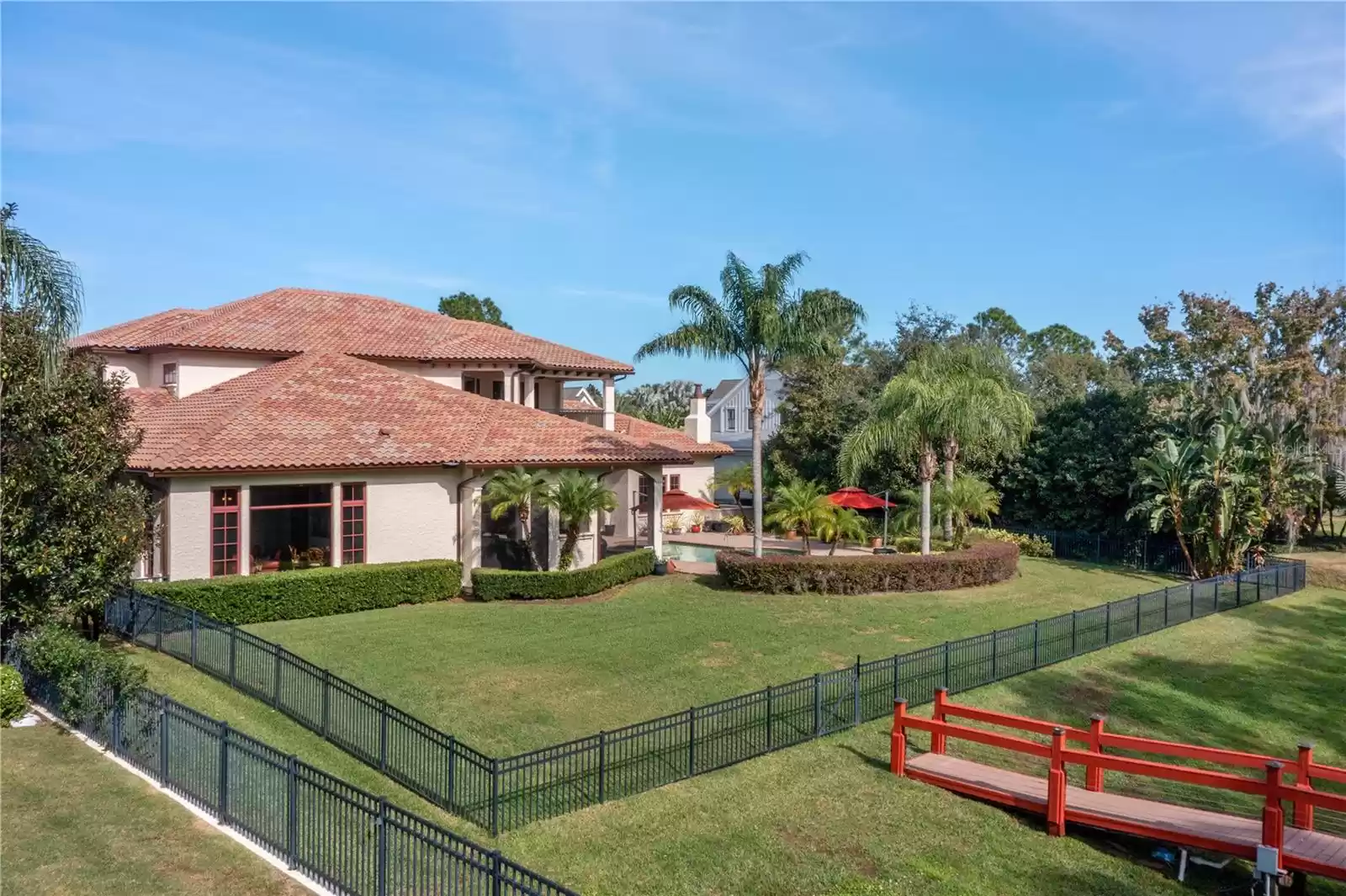 Impressive fenced back yard - Note picture window of the game room and the pristine boardwalk to the dock