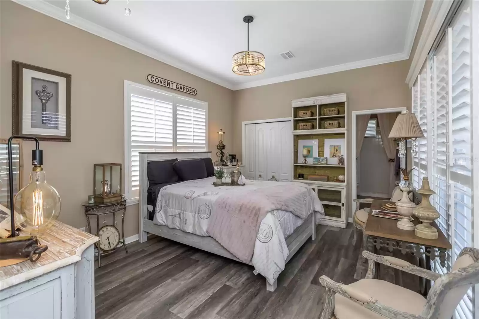 Bedroom 3 showing luxury vinyl flooring, ceiling fan, and sliding doors that open to the lanai