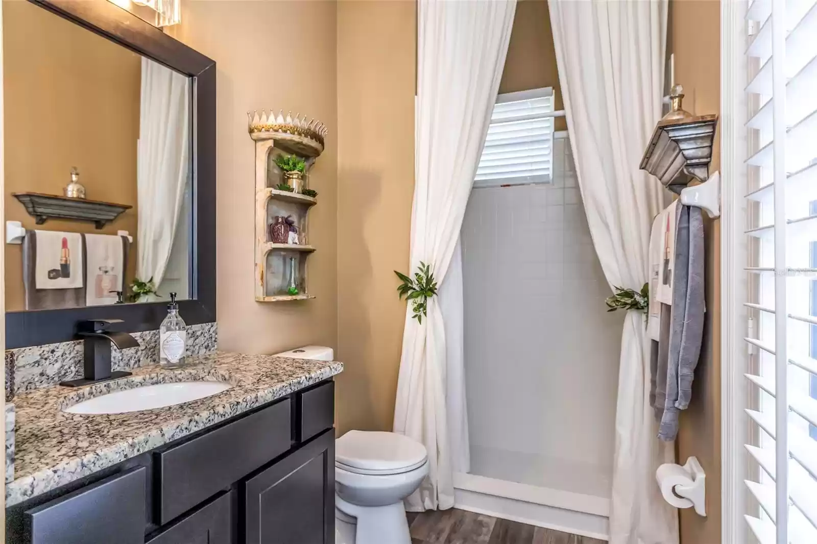 Bathroom of separate entrance ensuite, showing granite counter, step in shower and door to lanai