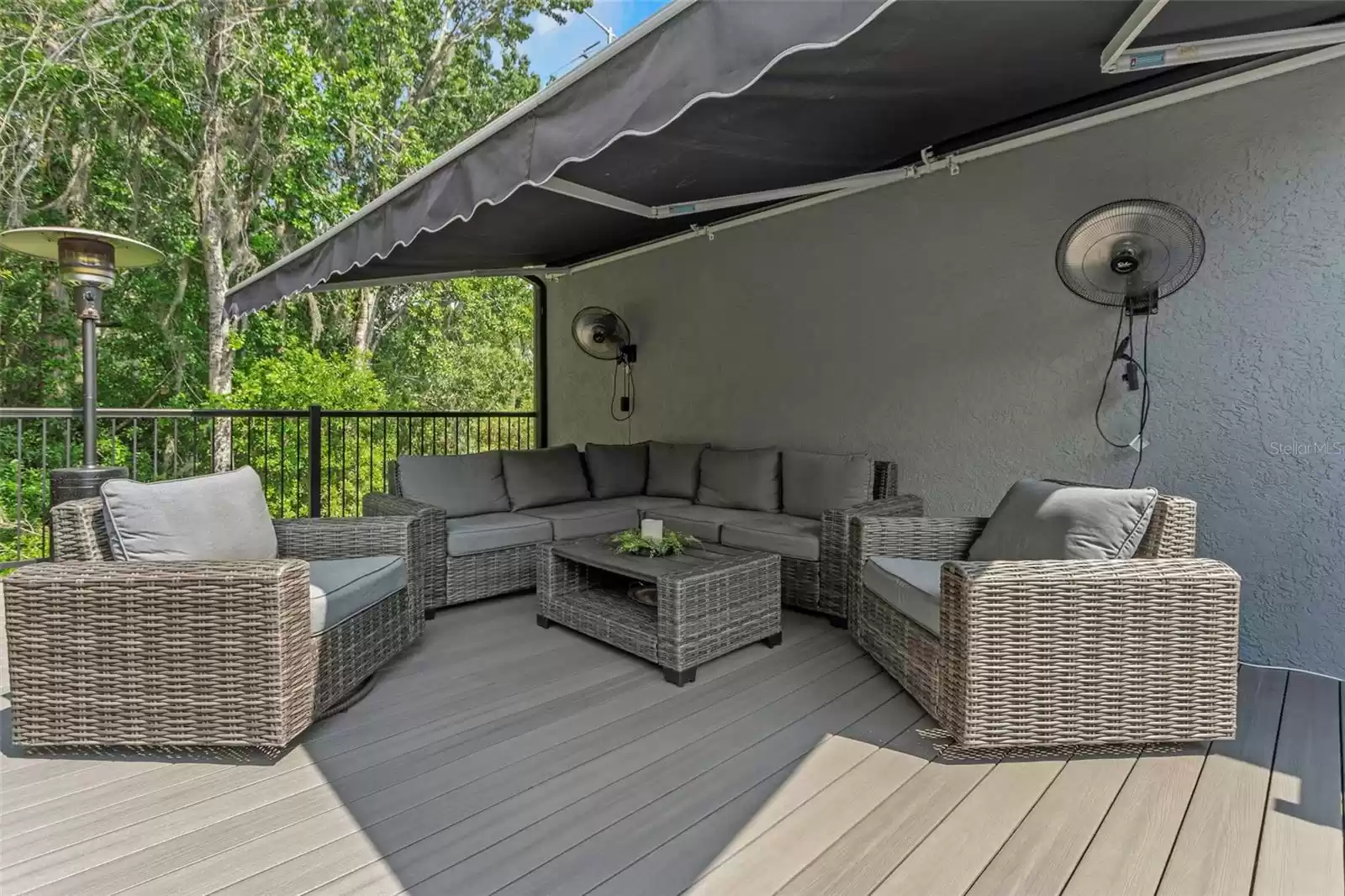 Additional outdoor seating on the smooth surface resin planked deck. Step up to complete privacy and relax in the shade of the motorized retractable awning, cooled by the rotating fans, while looking out over the mountain getaway feel from the lush preserve area that borders the property