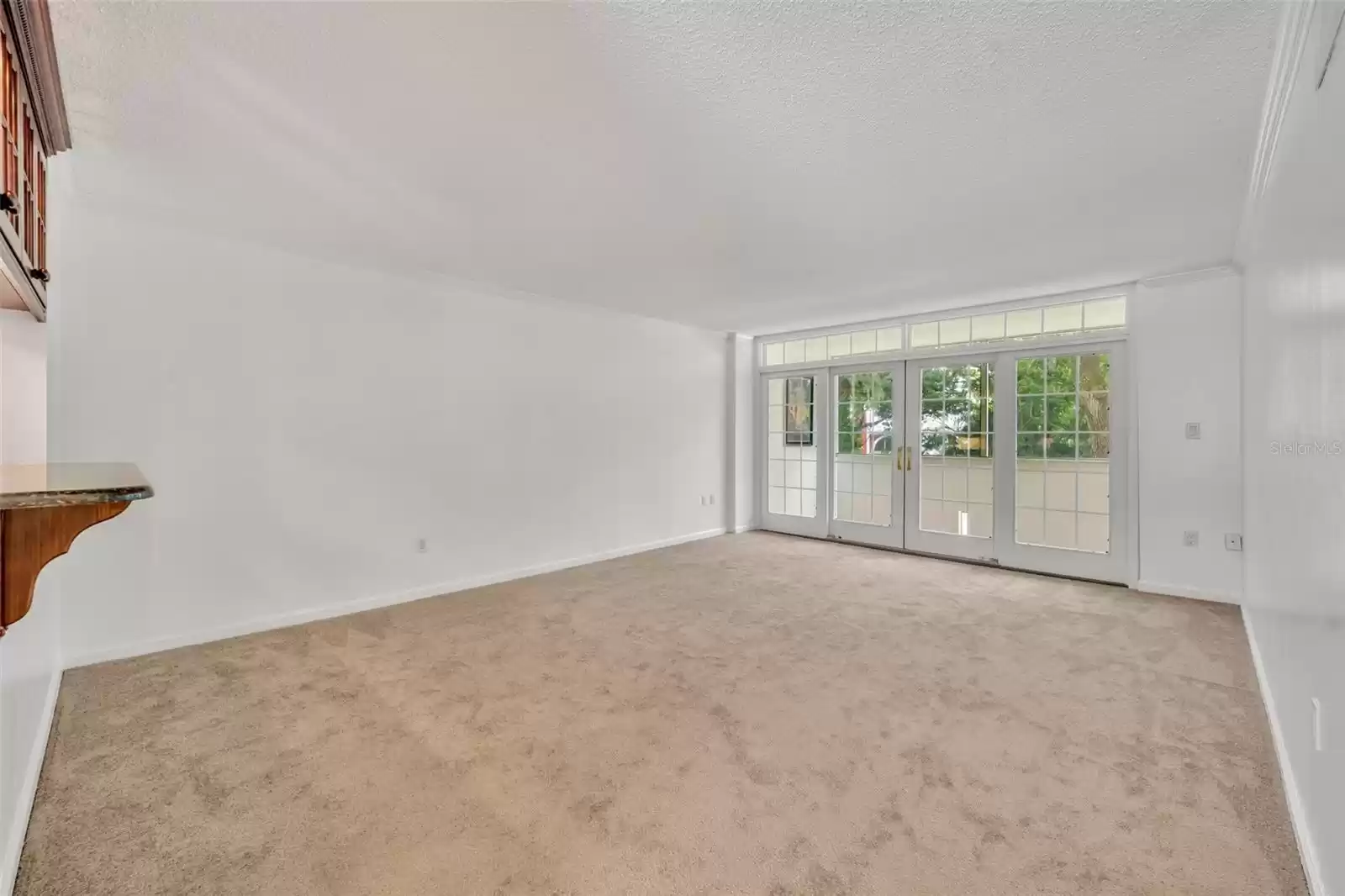 Living Room opens from kitchen. Glass cabinets