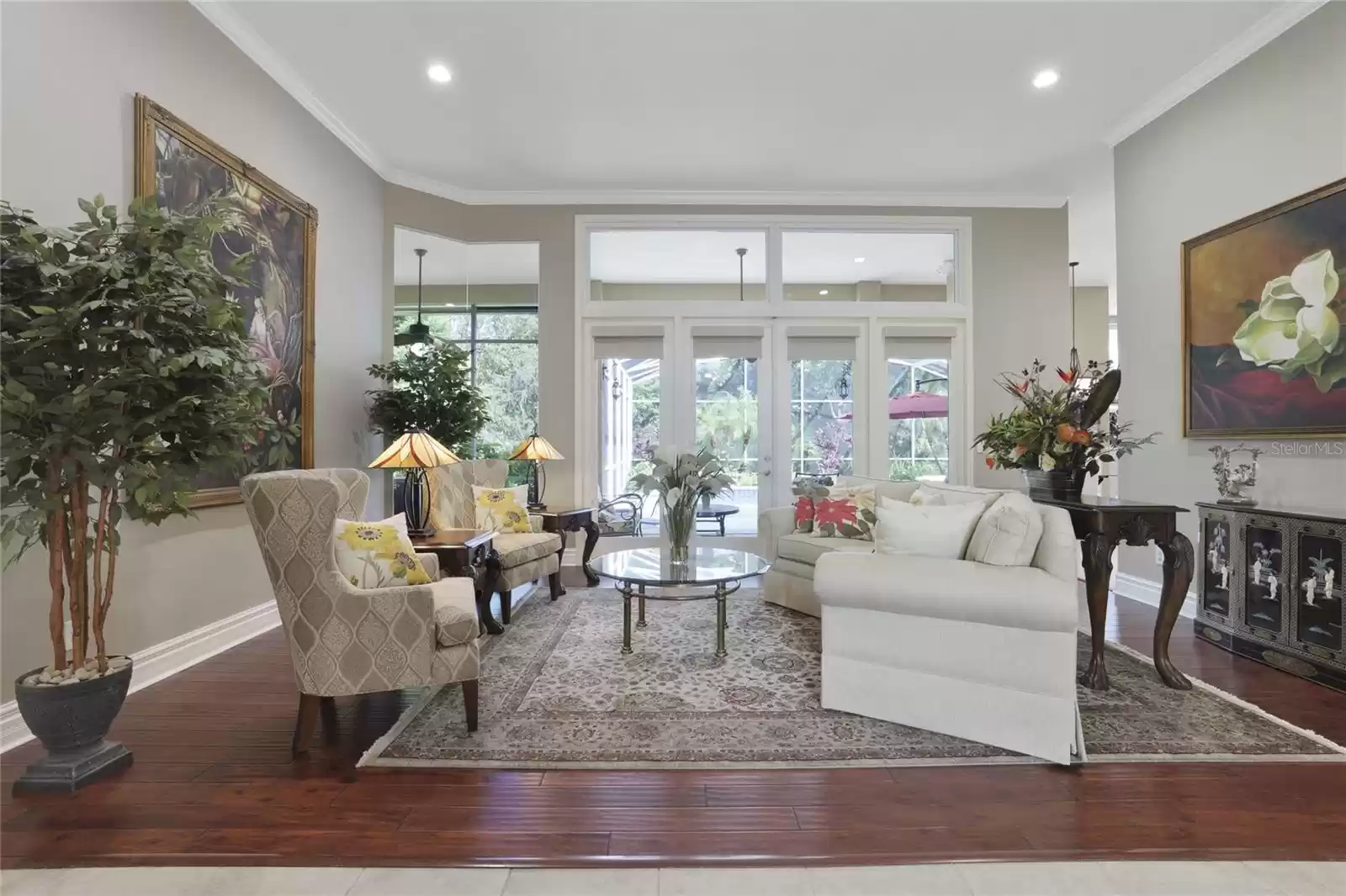 Living Room as you enter with views of the pool and upgraded landscaping.