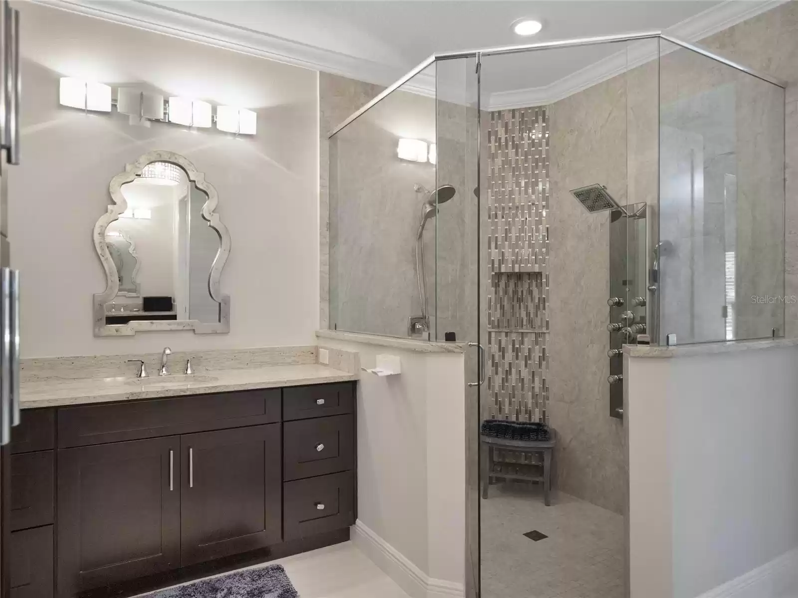 Primary bathroom featuring separate vanity areas and spacious shower and soaking tub leads in to the custom built in closet.