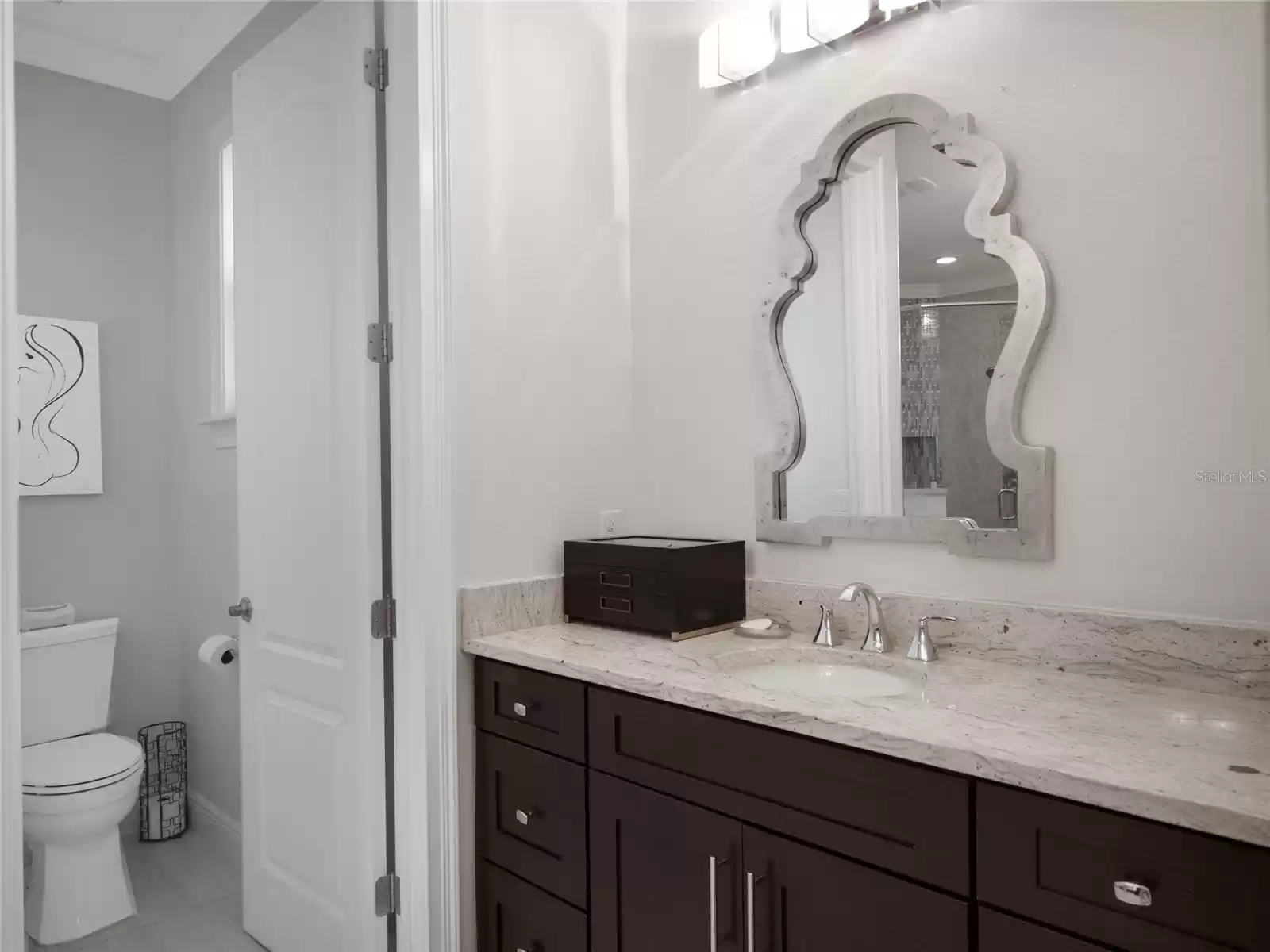 Primary bathroom featuring separate vanity areas and spacious shower and soaking tub leads in to the custom built in closet.