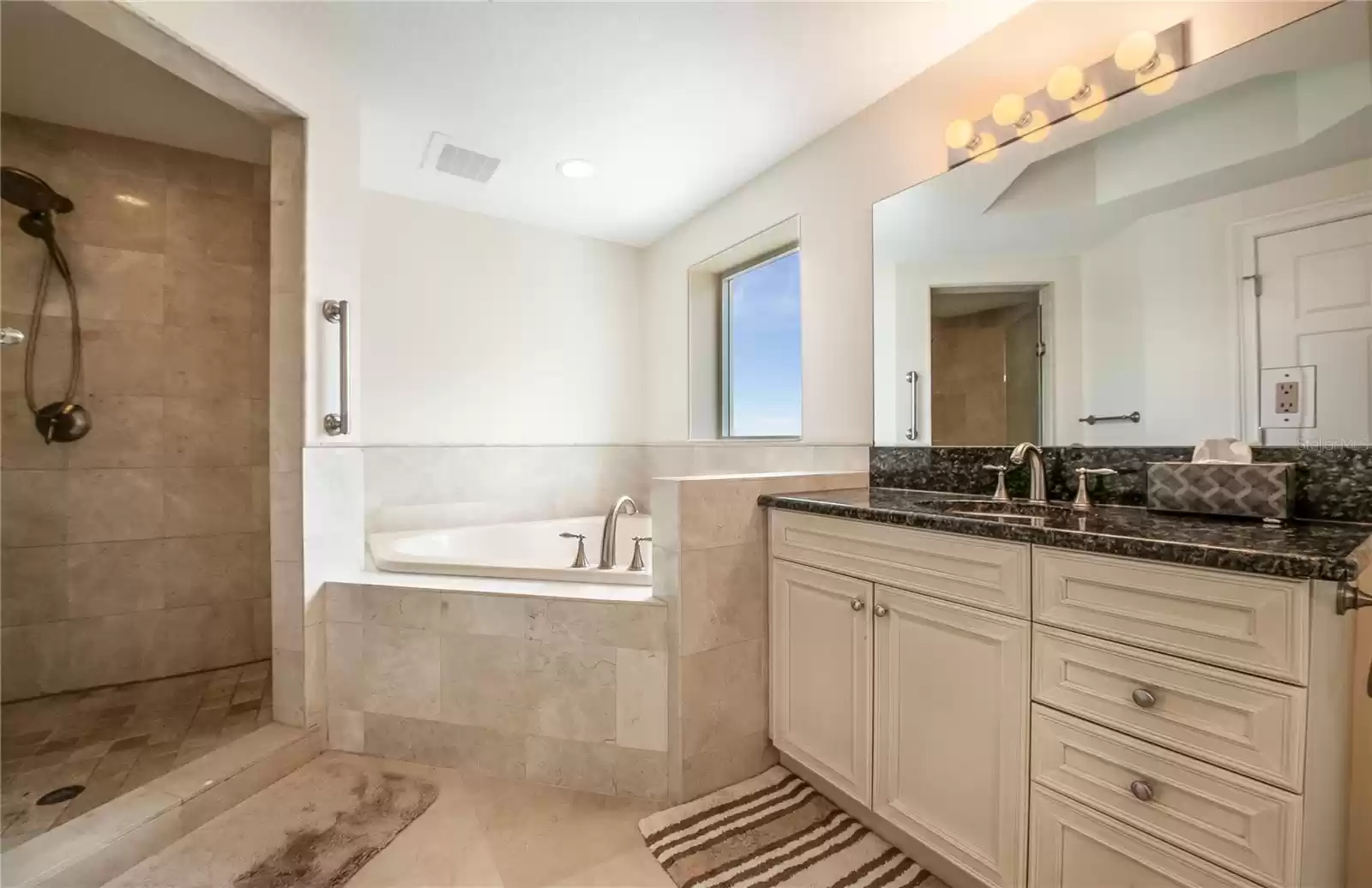 Master Bathroom With Two Vanities, Tub, and Shower