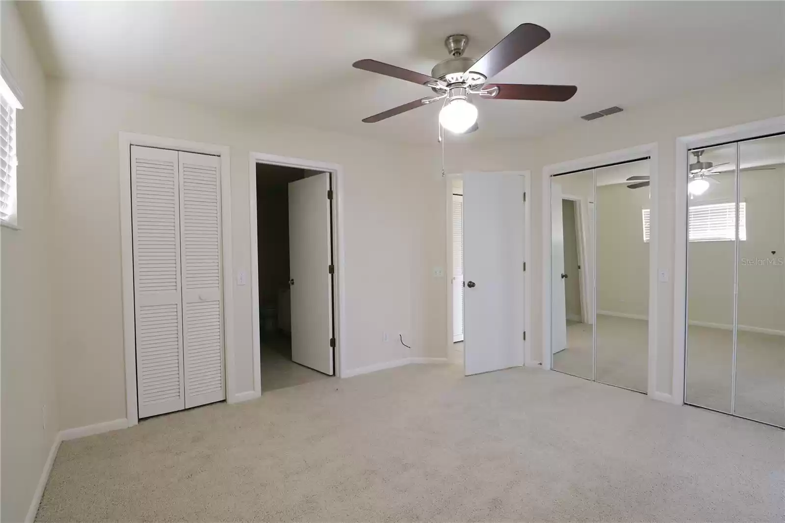 Master bedroom with dual closets and a walk in closet