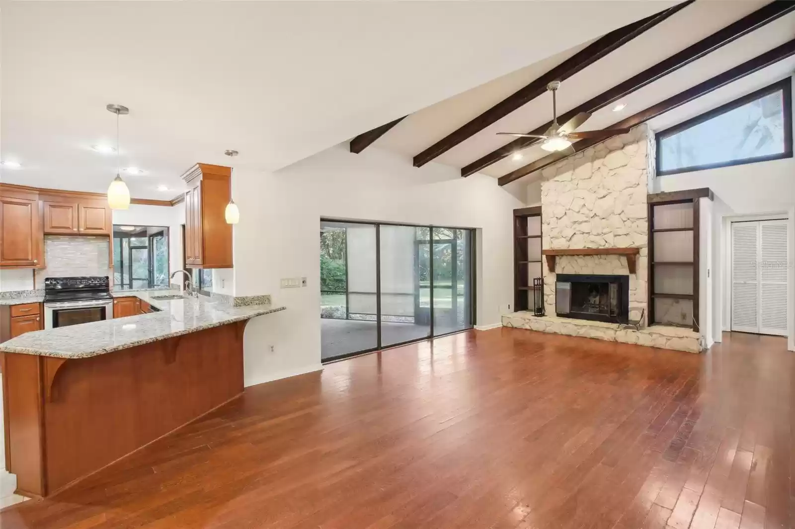 Large family room with stone fireplace and vaulted ceilings
