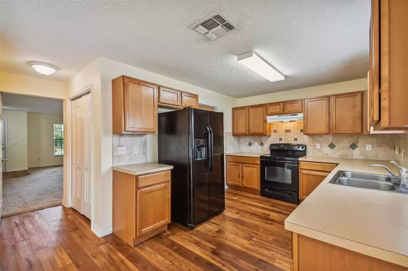 Kitchen features a tiled backsplash and plenty of cabinetry and prep space