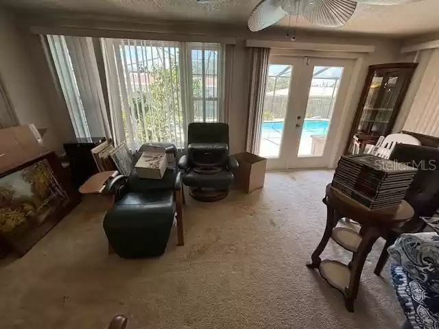 Step down into the family room area. Excuse the mess, owner is packing. Door opens out to the beautiful screened pool area.